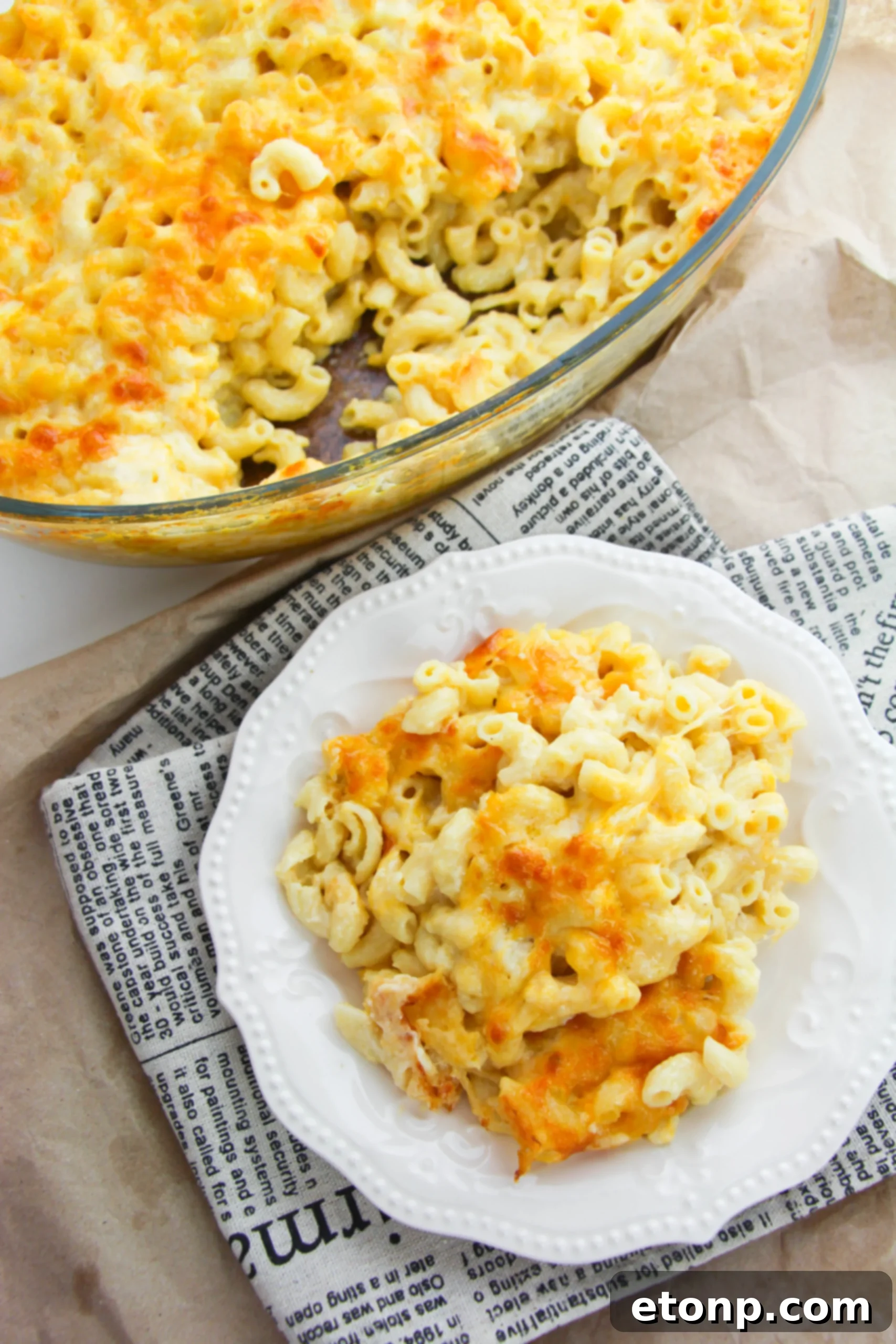 Macaroni and cheese served with a main dish, possibly steak or chicken, highlighting its role as a versatile side.