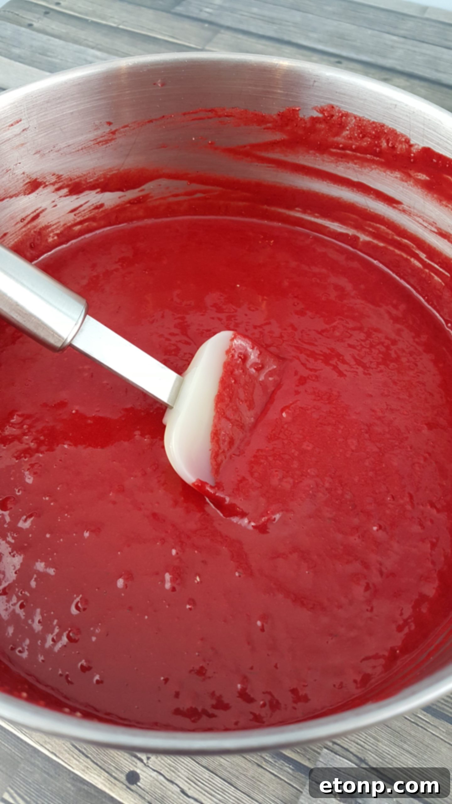 Hands preparing the chocolate cream cheese frosting, showcasing its smooth texture