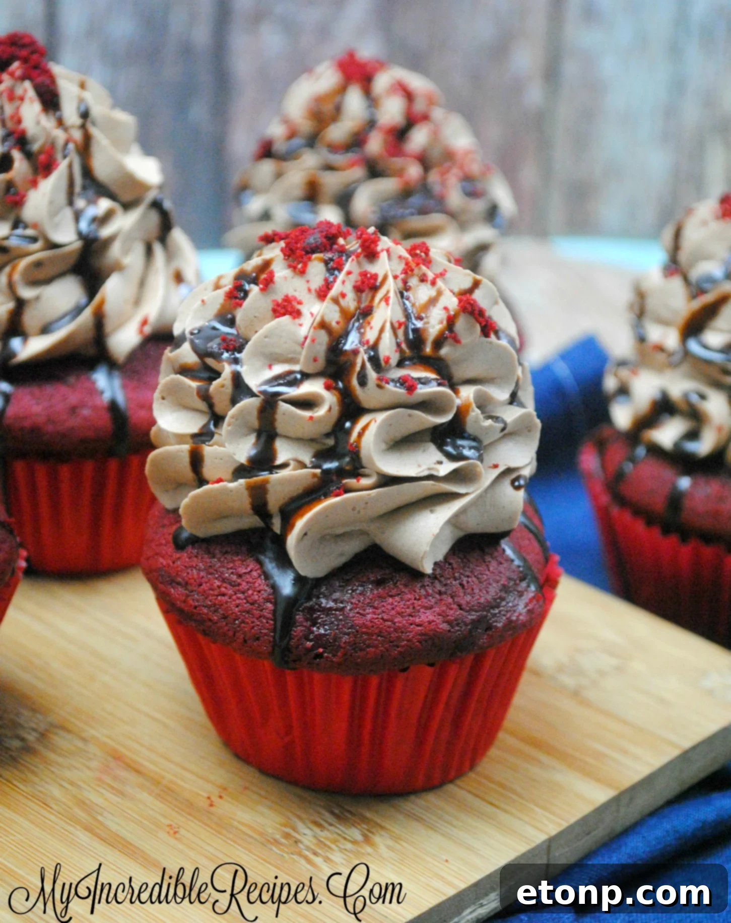 Several red velvet cupcakes adorned with the new chocolate cream cheese frosting