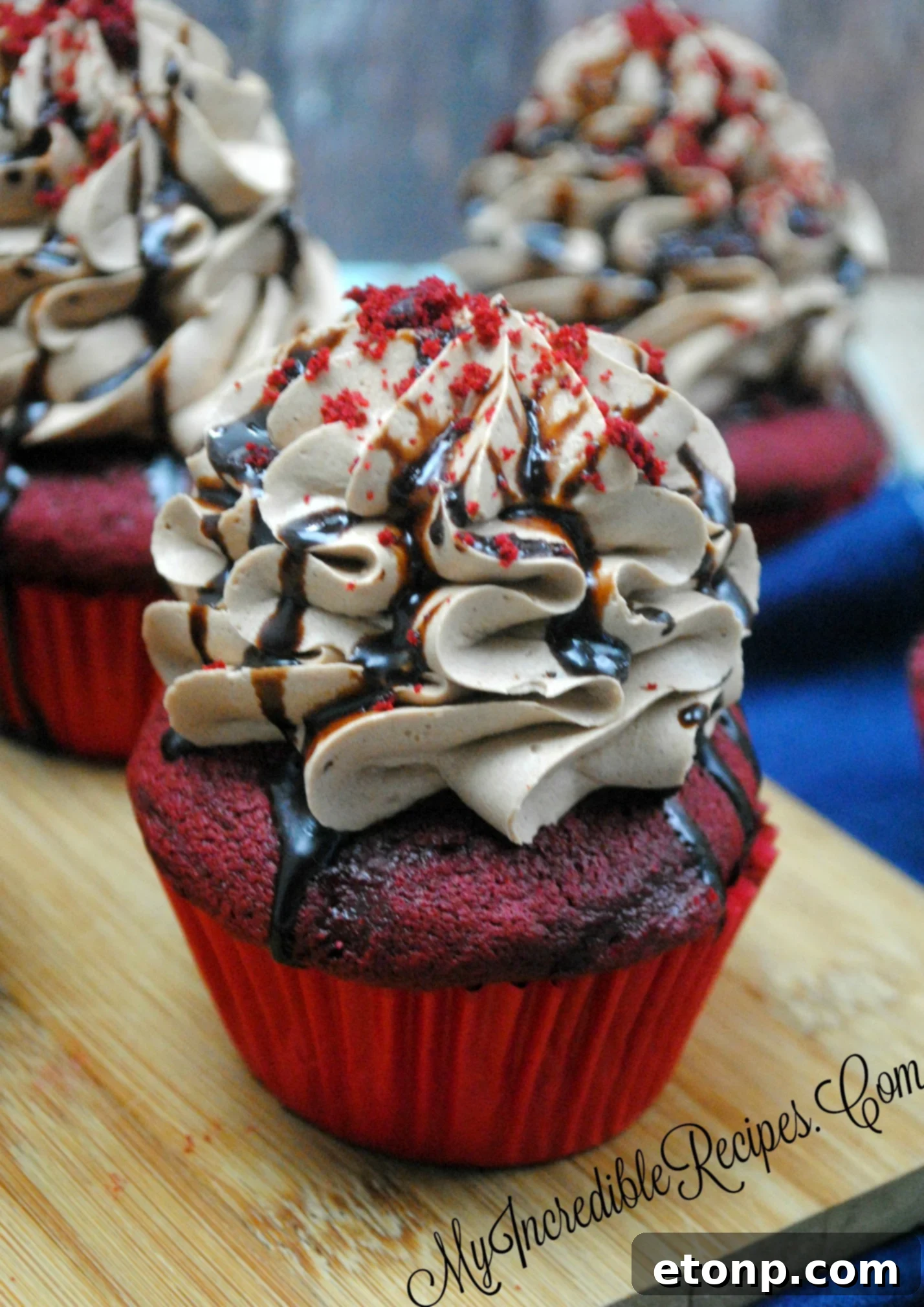 A close-up view of a frosted red velvet cupcake, ready for additional toppings