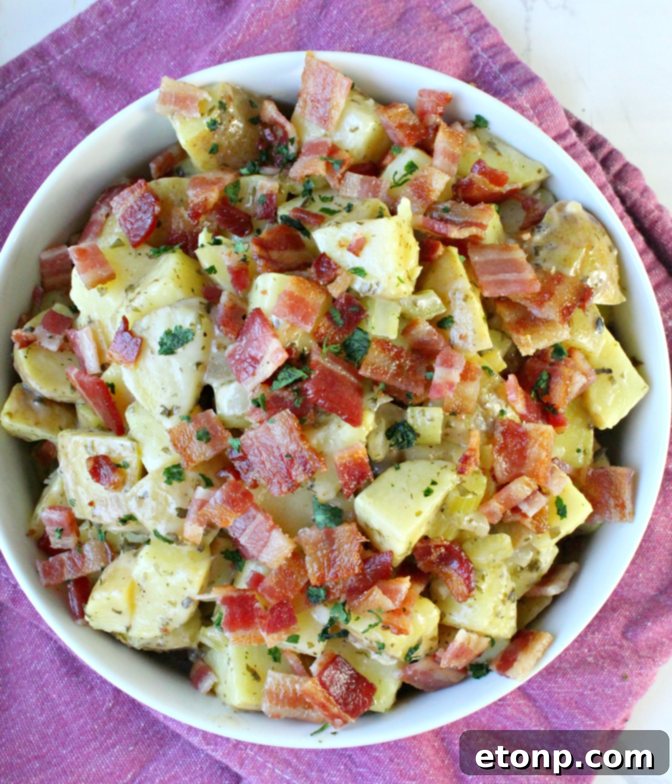 Close-up of German Potato Salad garnished with fresh herbs, ready to be served