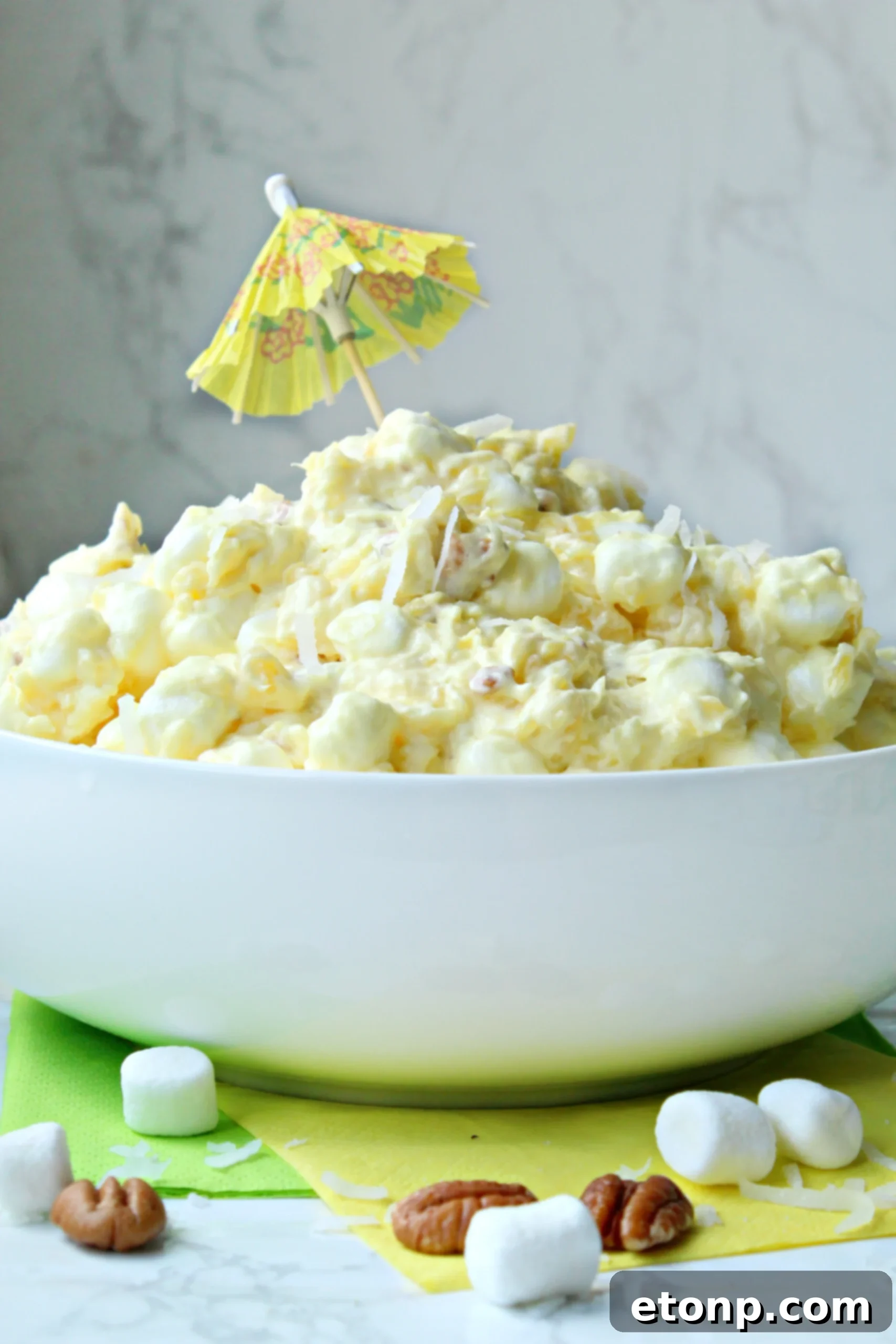 A bowl of Pina Colada Fluff with a spoon, highlighting its inviting, fluffy texture and tropical appeal.
