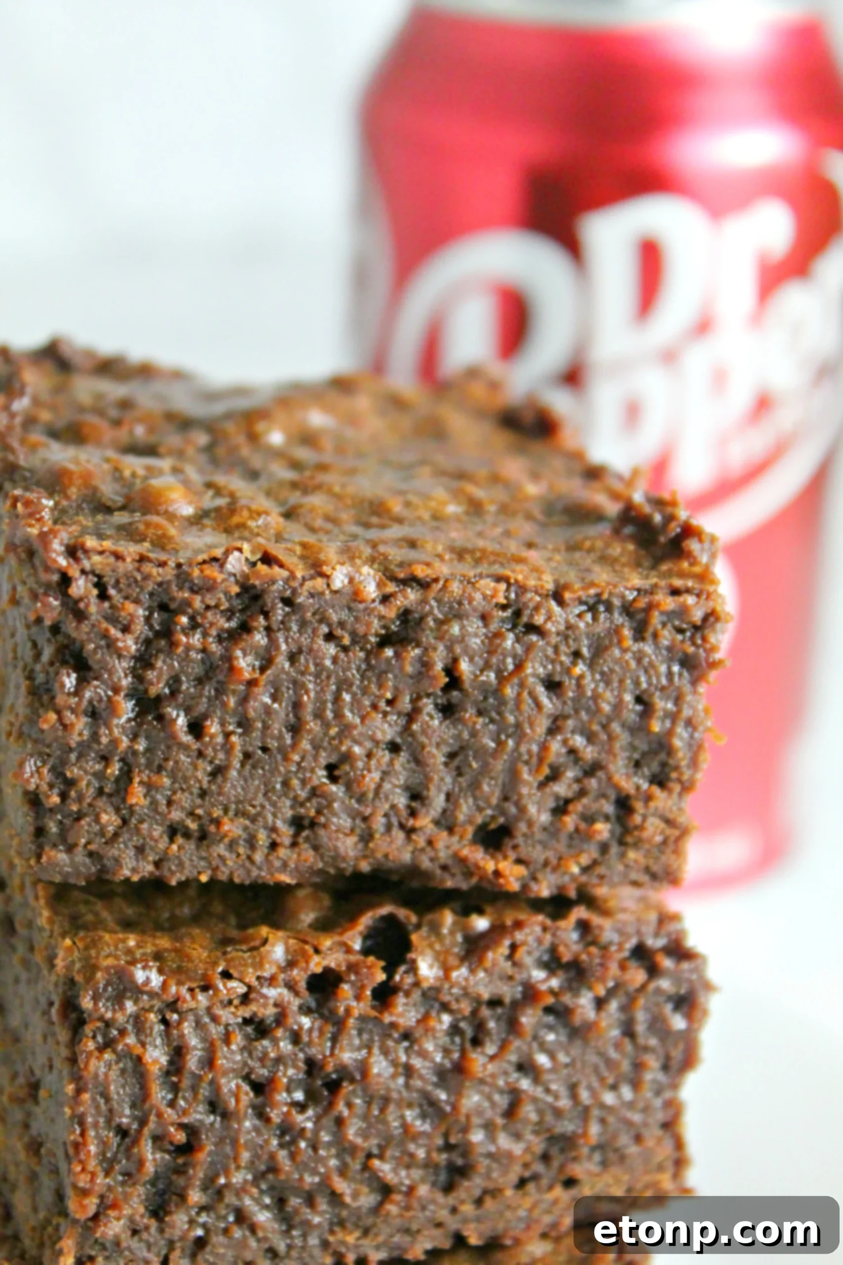 Decadent Dr Pepper Brownies 6 Hand holding a toothpick, checking the doneness of Dr. Pepper brownies in a baking dish