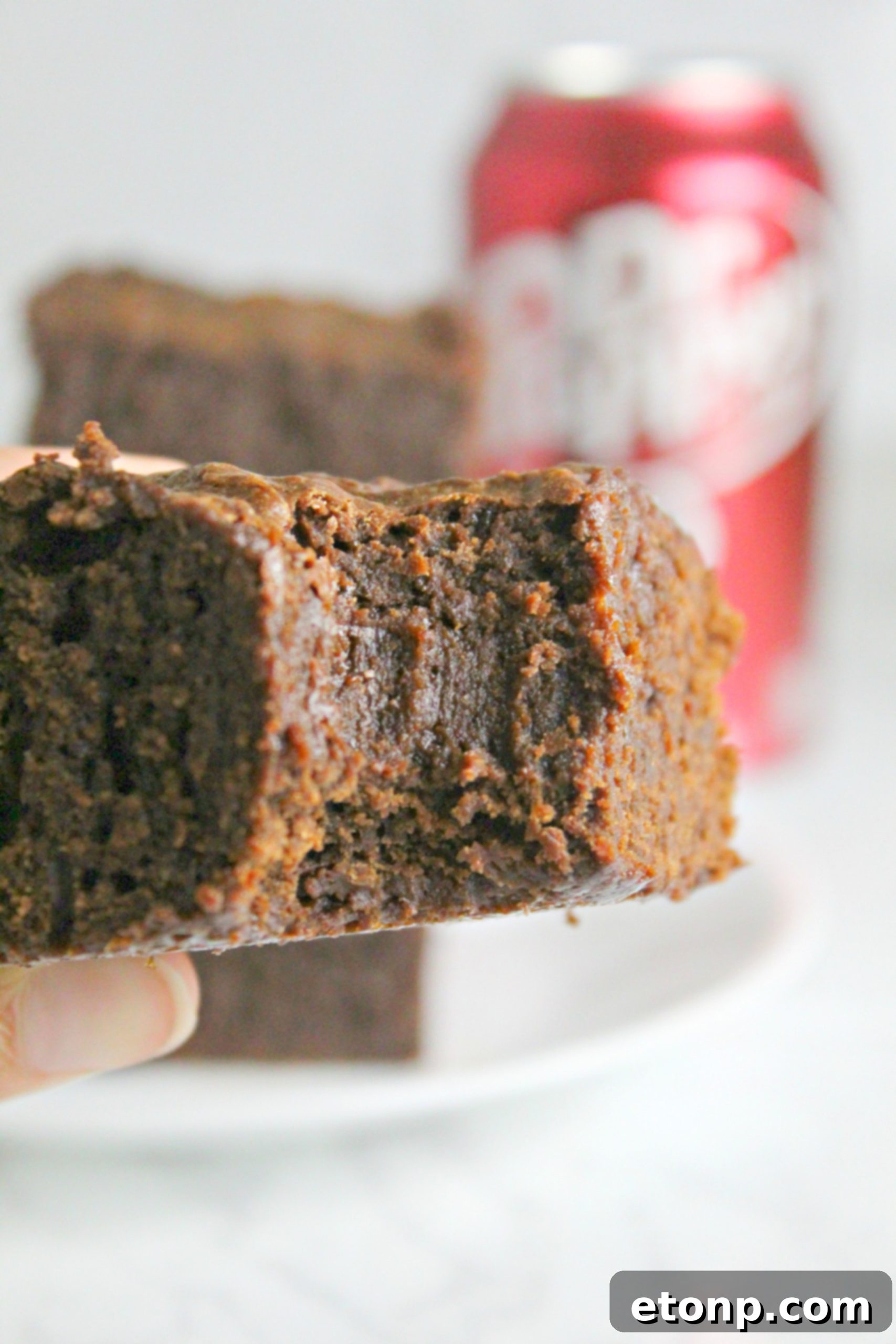 Decadent Dr Pepper Brownies 8 Dr. Pepper brownies drizzled with a sweet white glaze, glistening under the light