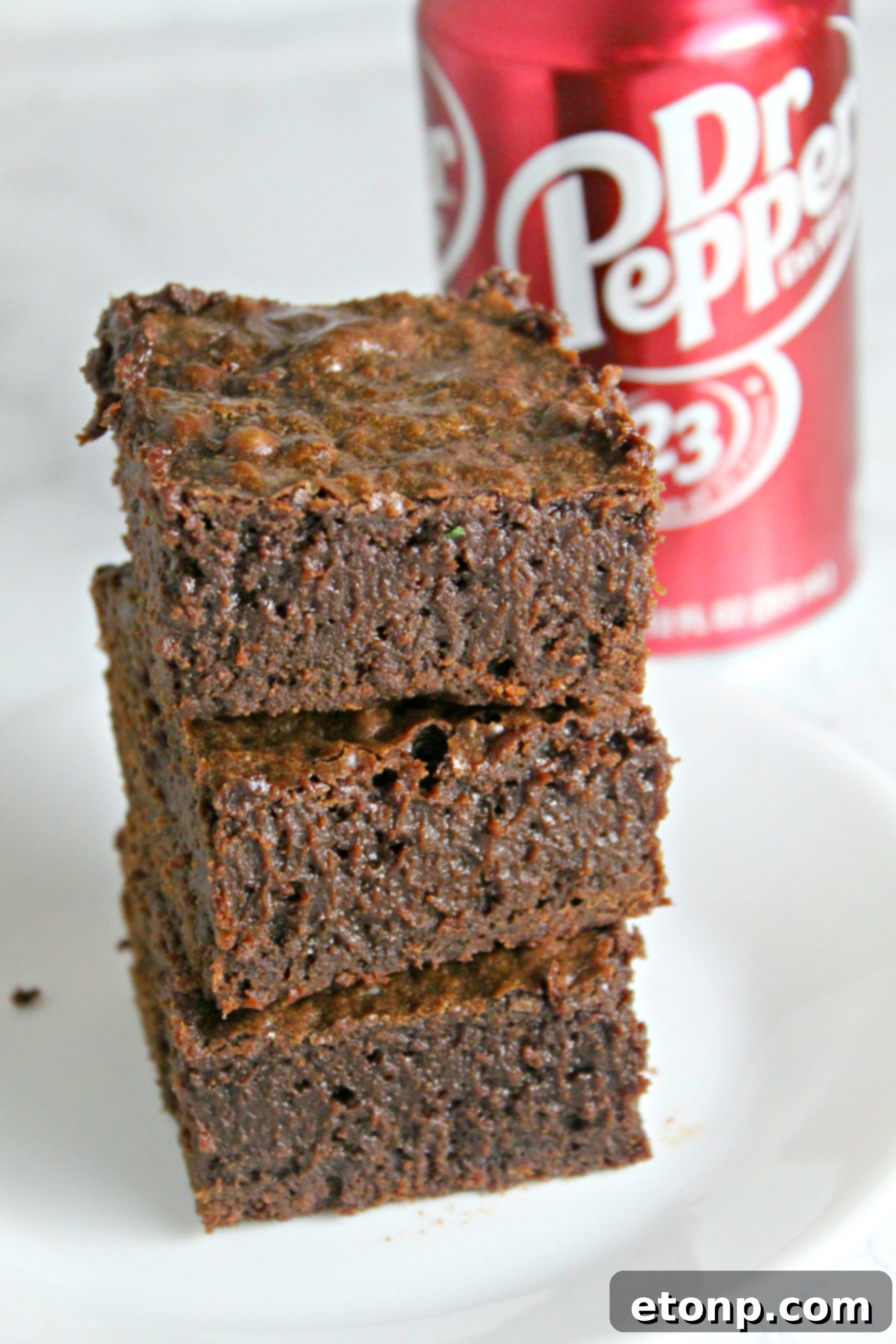 Decadent Dr Pepper Brownies 10 Dr. Pepper brownies stored in an airtight container on a kitchen counter