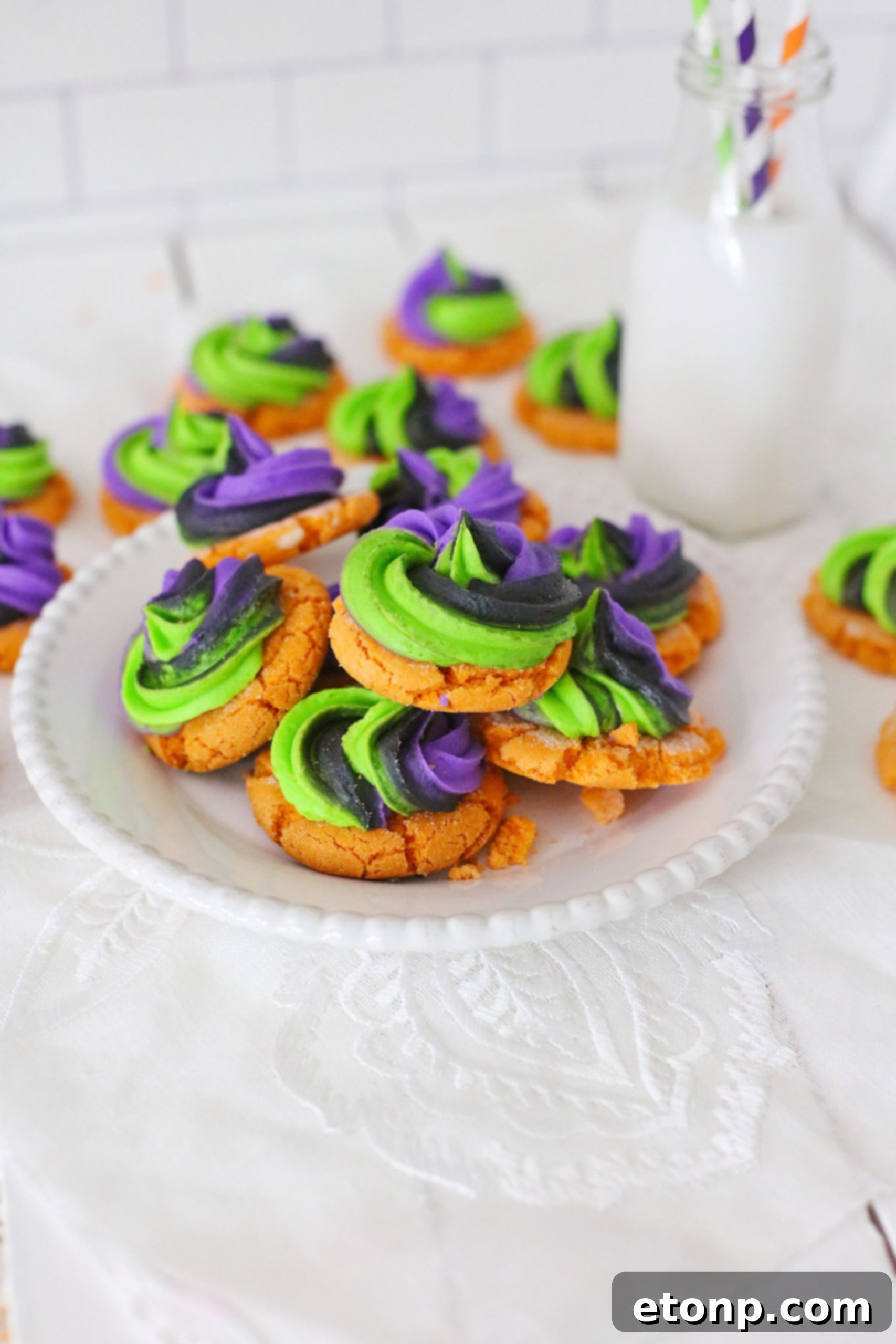 Several pumpkin sugar cookies with intricate, colorful buttercream icing designs on a dark background.