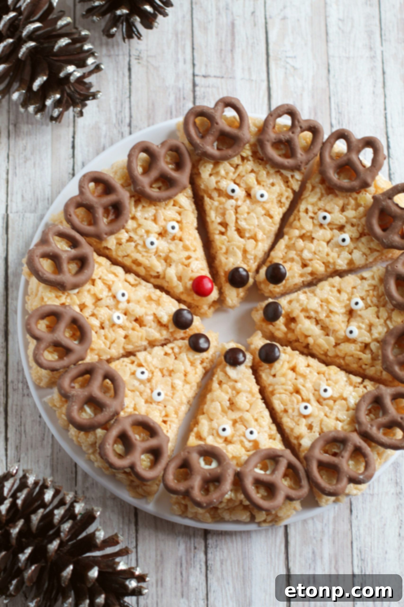 A close-up shot emphasizing the cute details of Reindeer Rice Krispie Treats, including their chocolate pretzel antlers and cheerful candy eyes.