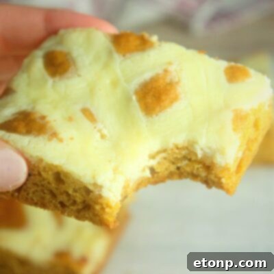 A warm, inviting image of a baked Extreme Cream Cheese Pumpkin Bar slice.
