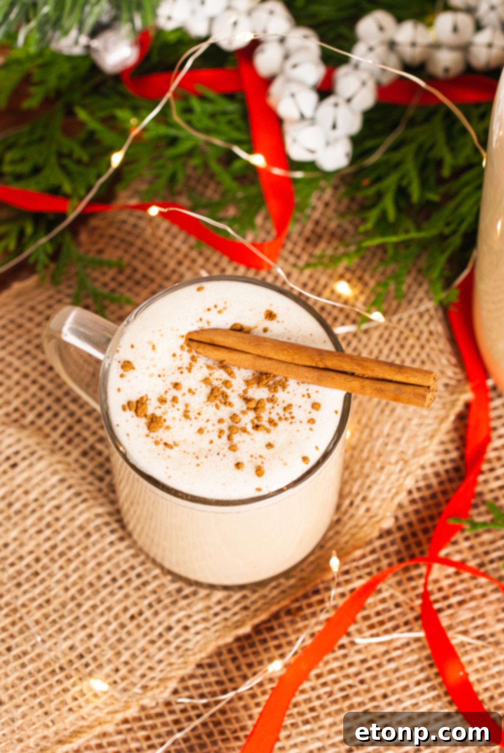 Freshly grated nutmeg over homemade eggnog in a glass, highlighting the rich holiday spices.