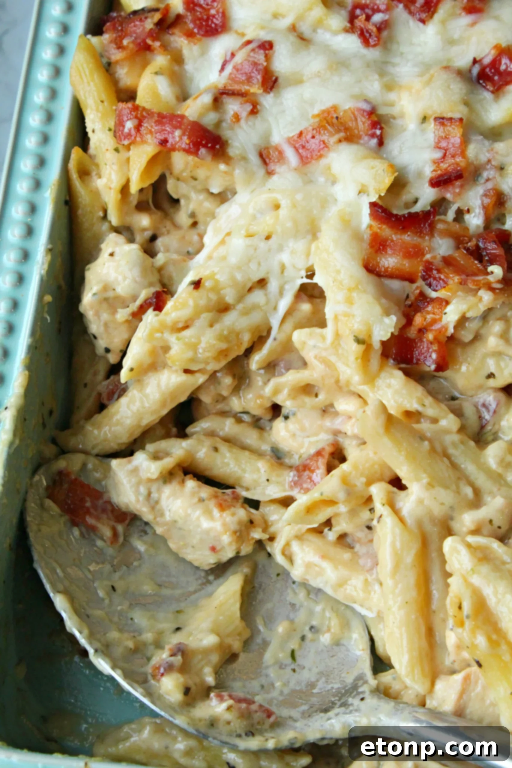 Ultimate Chicken Bacon Ranch Penne 2 A close-up shot of a creamy Chicken Bacon Ranch Penne dish, rich with pasta, chicken, bacon, and melted cheese.