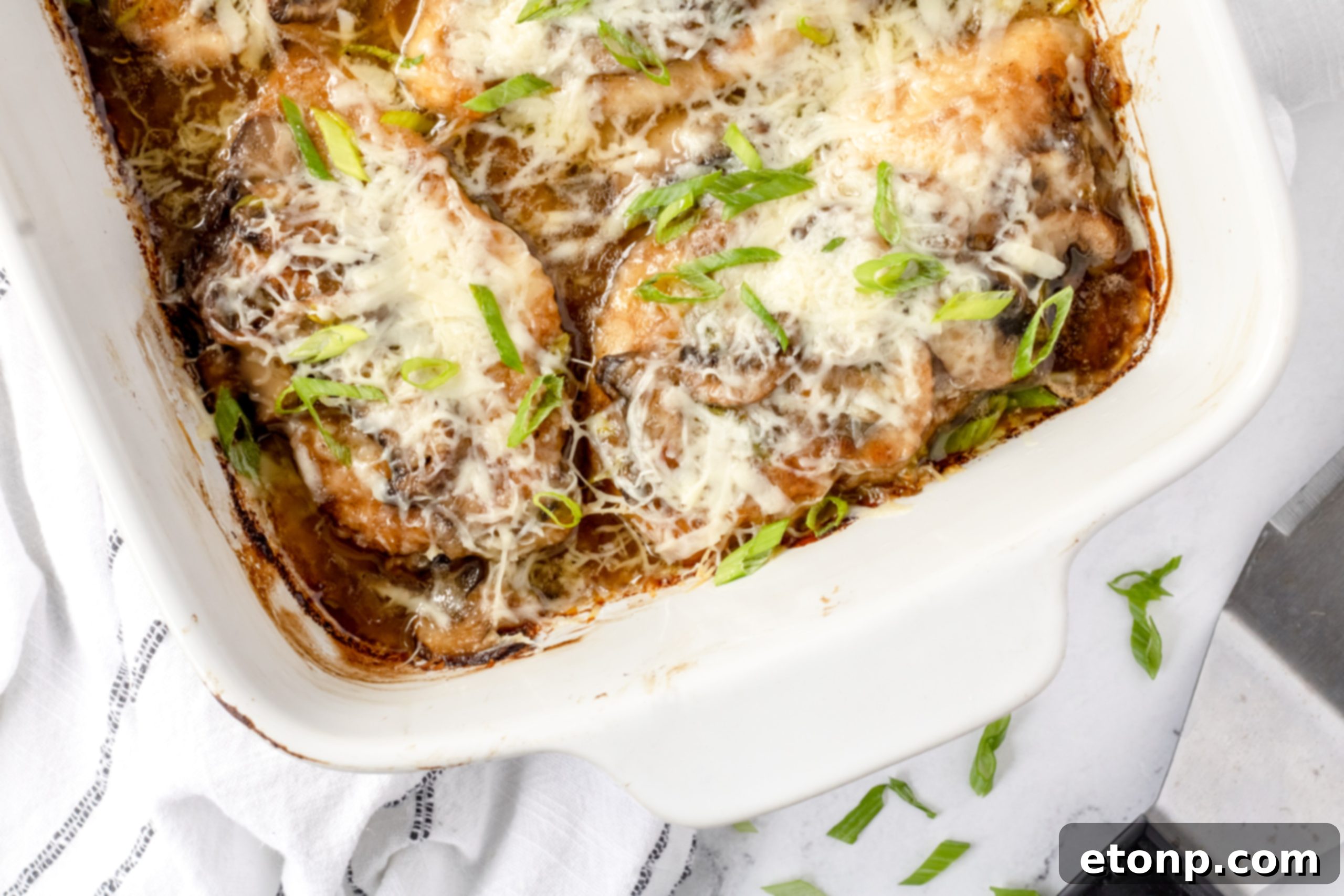 A full baking dish of freshly baked Chicken Lombardy, still bubbling from the oven, with the golden-brown chicken, rich sauce, and melted Parmesan cheese clearly visible, ready to be served.