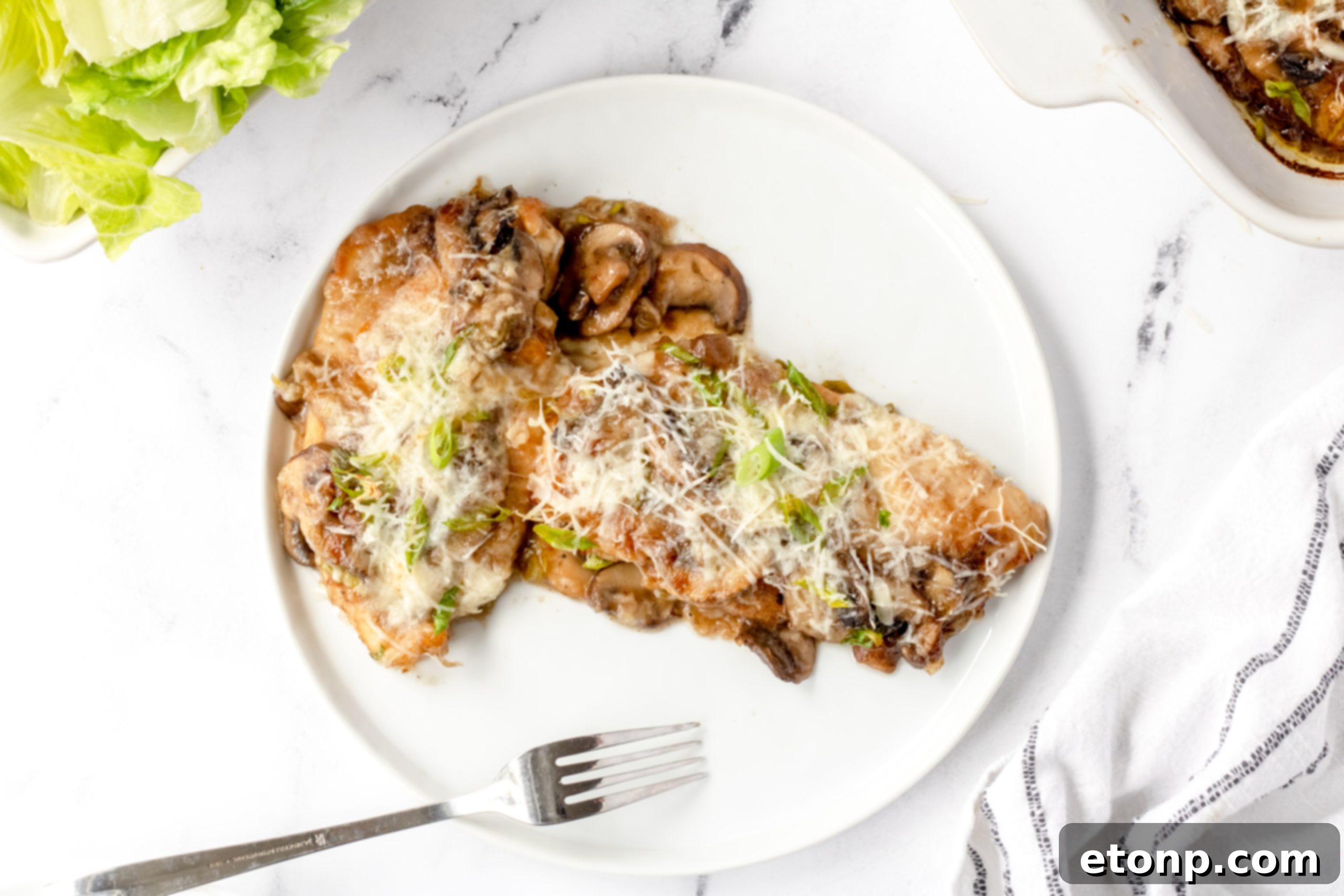 Various ingredients for Chicken Lombardy laid out on a kitchen counter, including fresh chicken breasts, sliced mushrooms, green onions, and a bottle of Marsala wine, emphasizing fresh preparation.