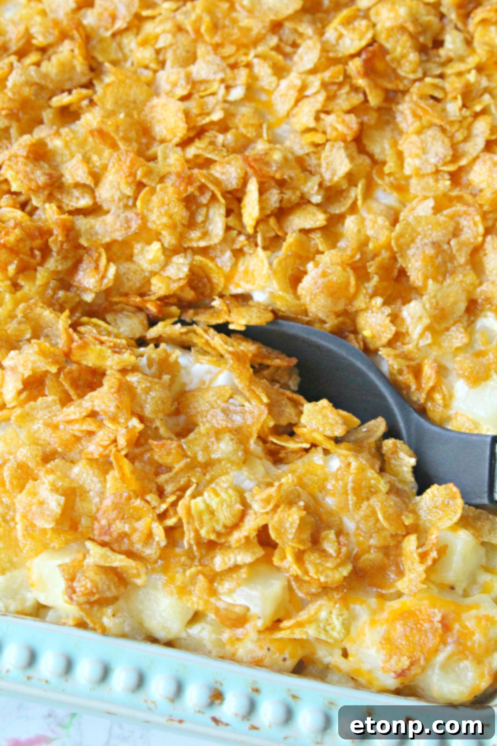 A large serving of Funeral Potatoes in a baking dish, cut into squares.