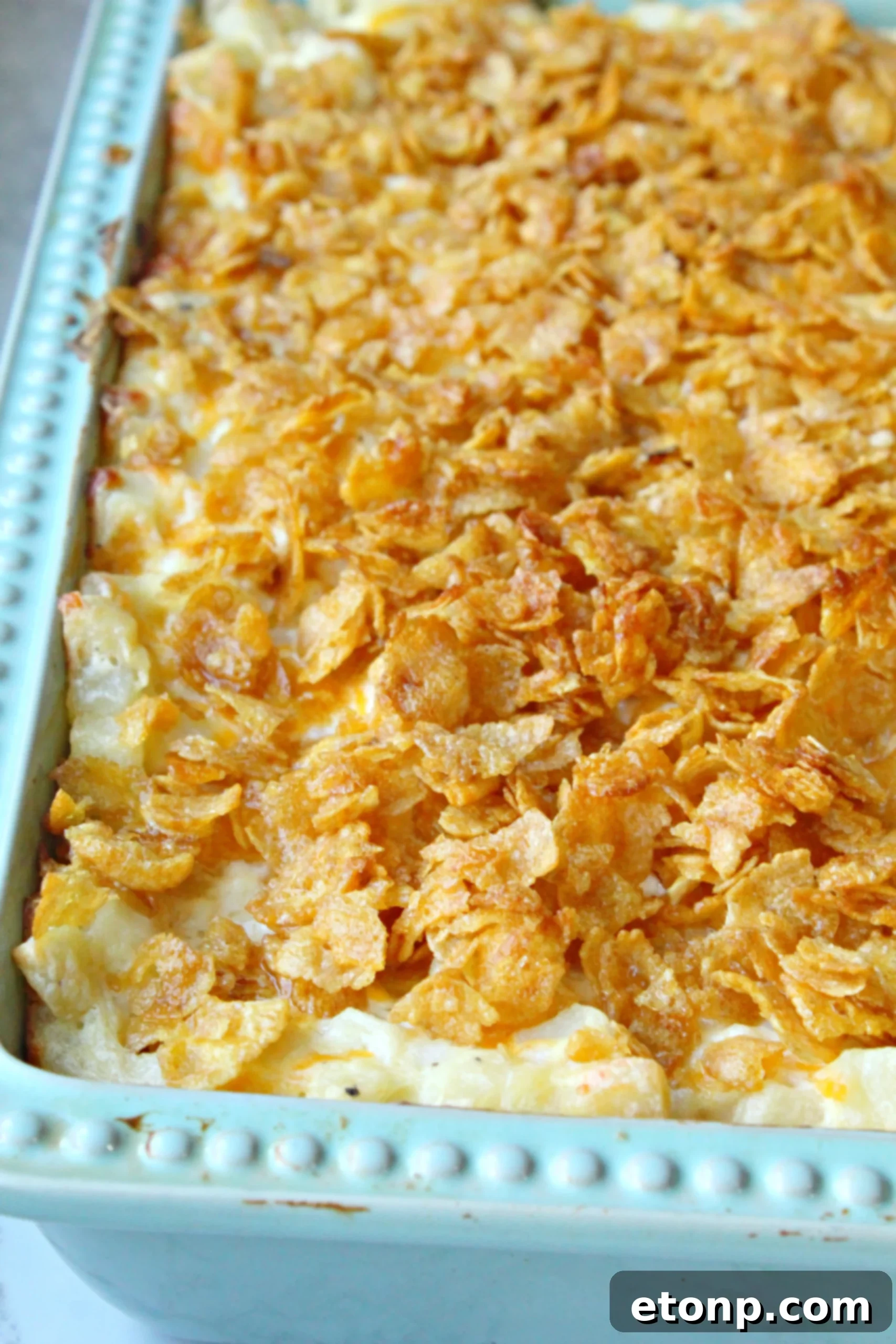 A dish of Funeral Potatoes wrapped in aluminum foil, ready for storage or freezing.