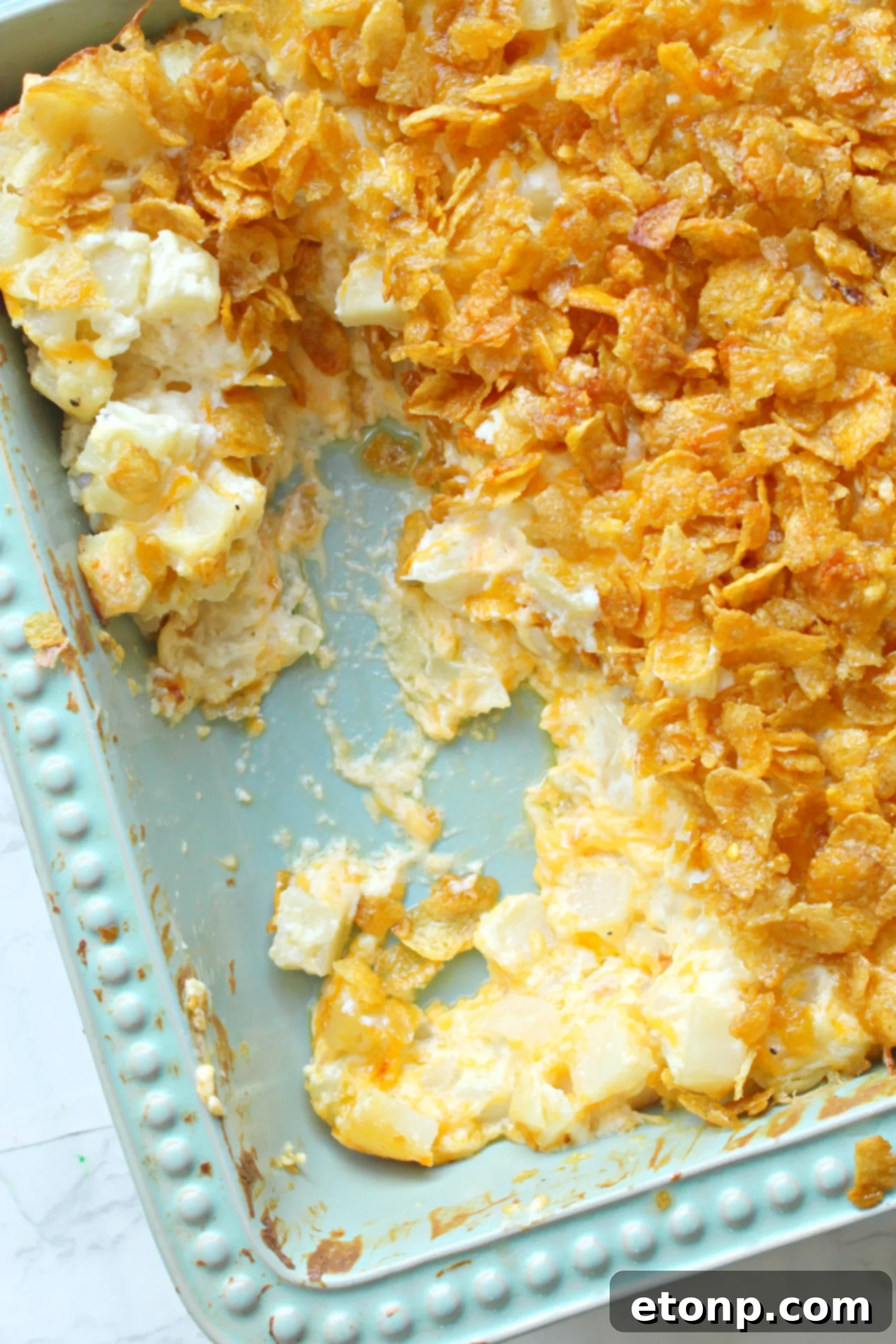 A holiday spread featuring Funeral Potatoes alongside a glazed ham and other festive dishes.