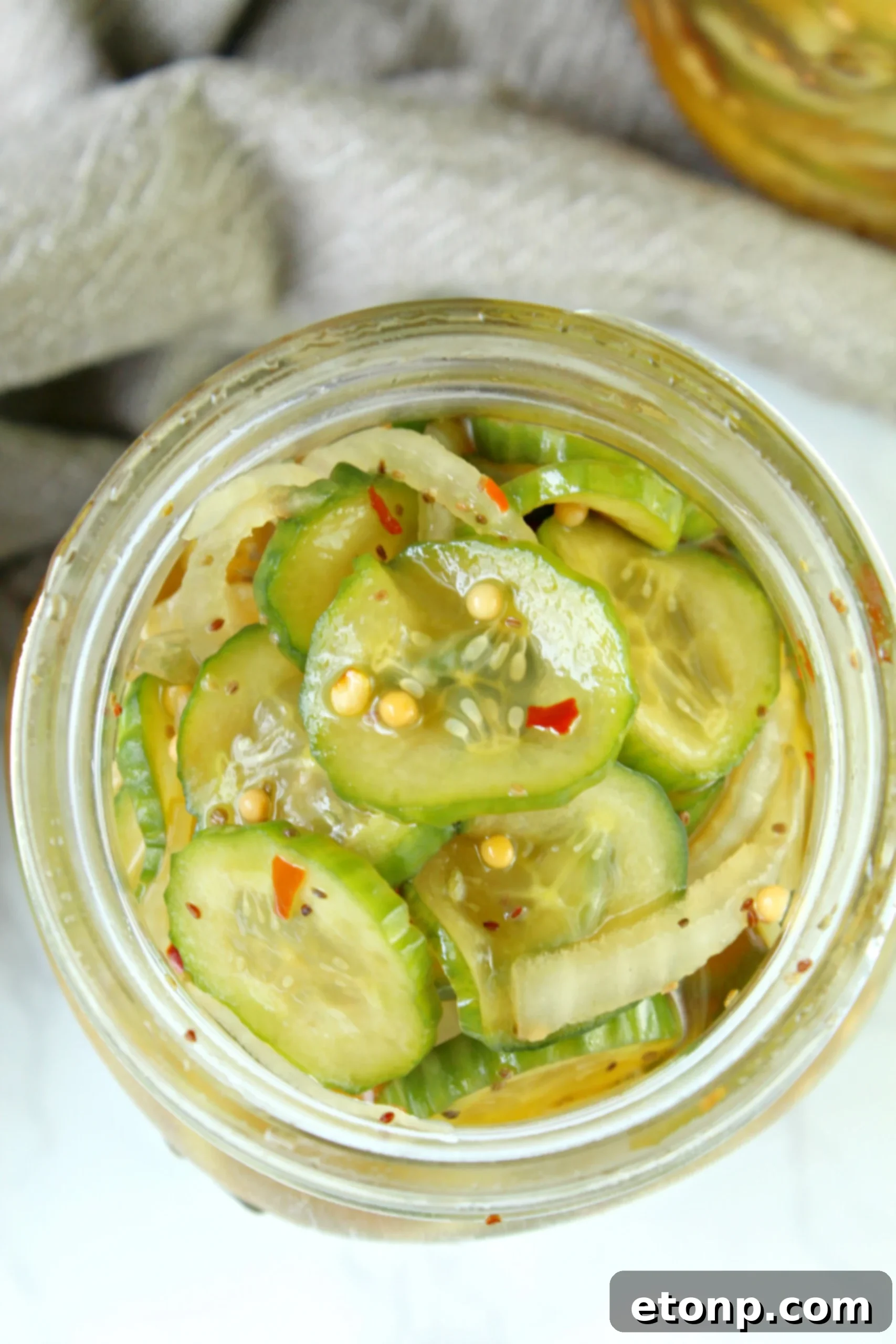 A final shot of a hand reaching for a jar of homemade bread and butter pickles, emphasizing their delicious appeal and readiness to be enjoyed.