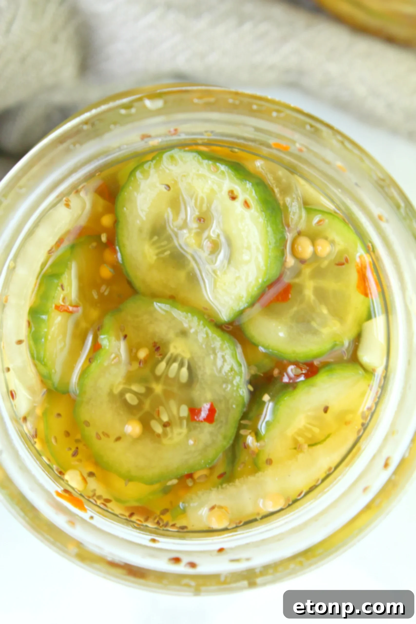 Several neatly arranged glass jars filled with homemade bread and butter pickles, showcasing different sizes and styles of presentation, ready for storage.