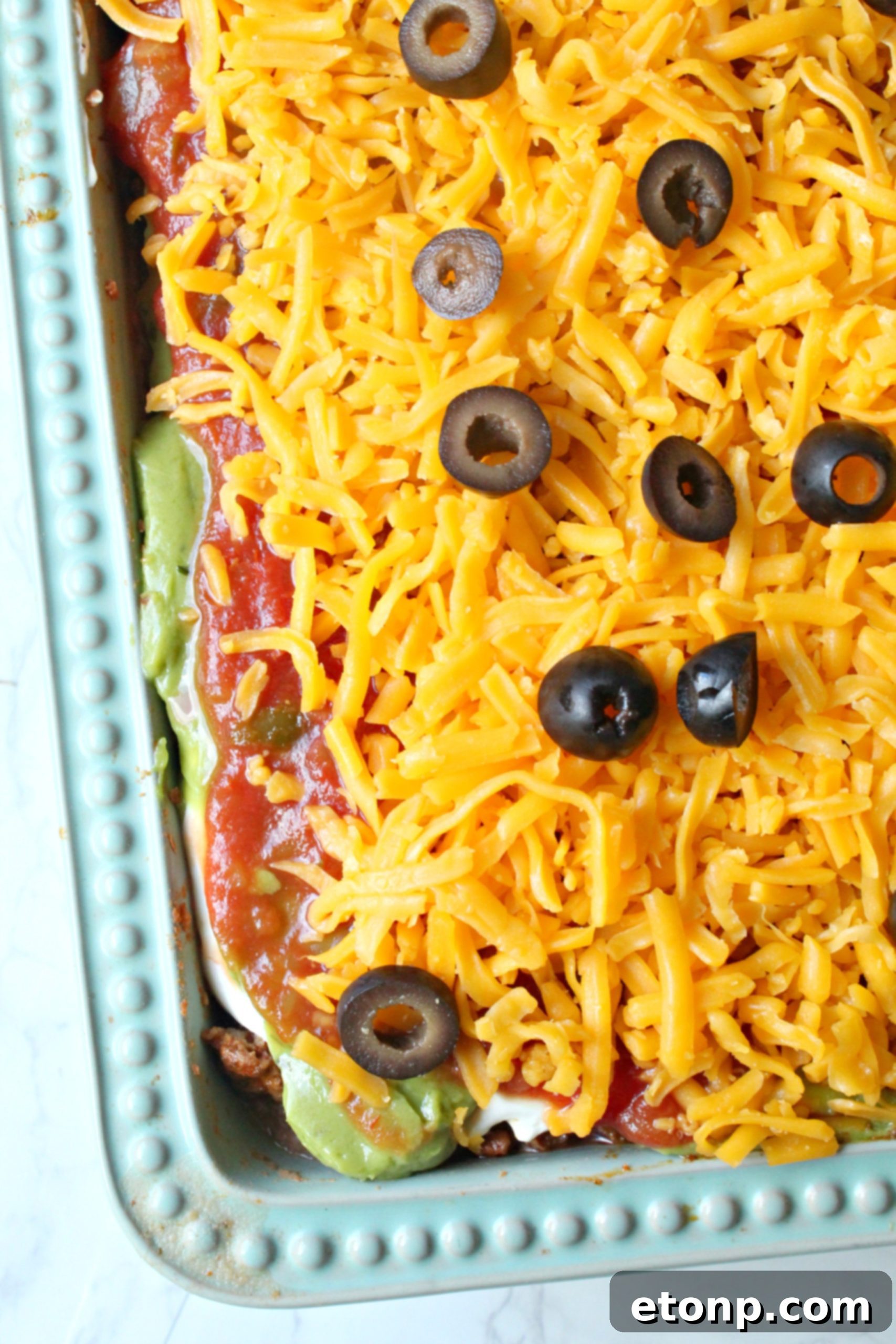 7 layer taco dip overhead shot in a blue baking dish