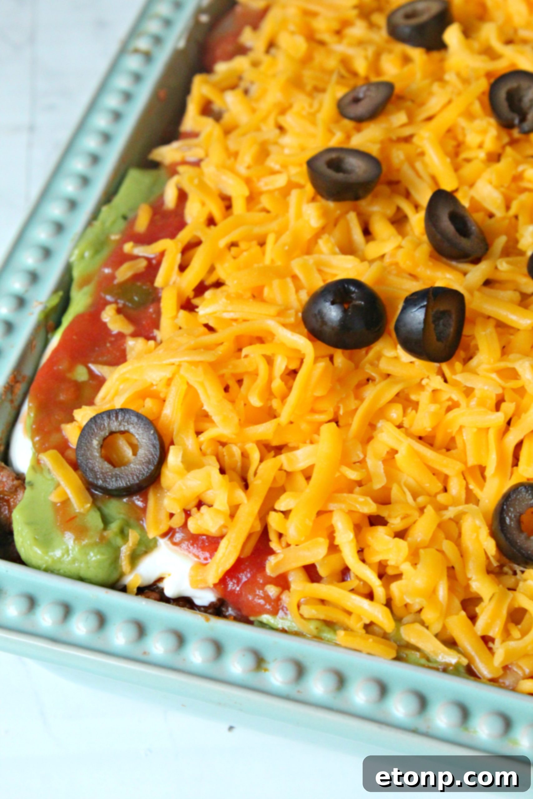 7 layer taco dip topped with cheese and olives close up
