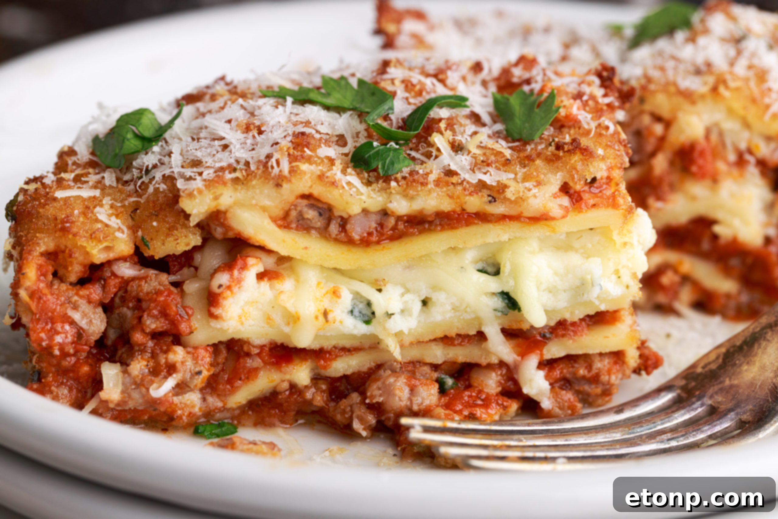 Deep fried lasagna on a serving plate with fresh basil garnish