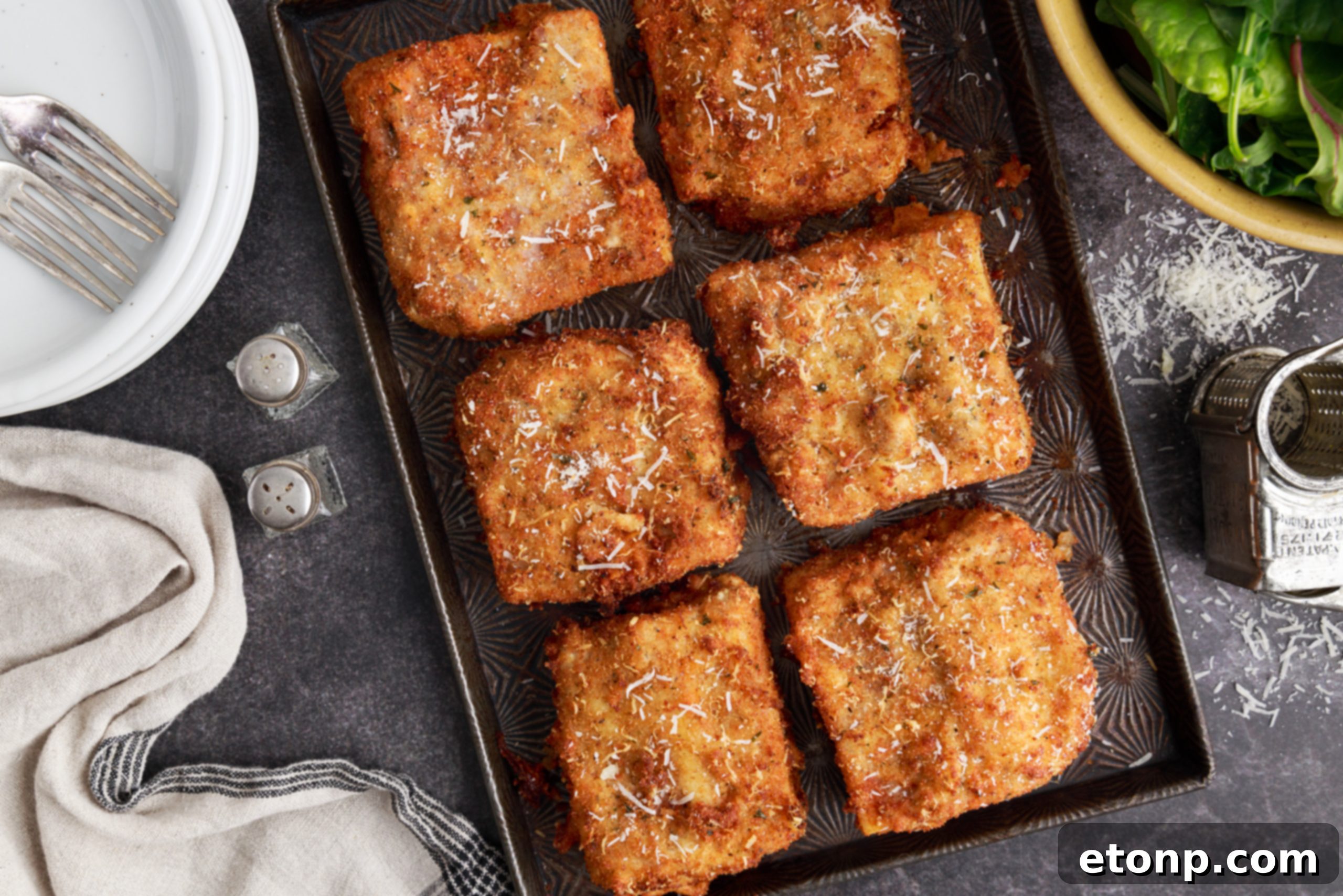 Deep fried lasagna slices ready for serving, garnished with fresh herbs