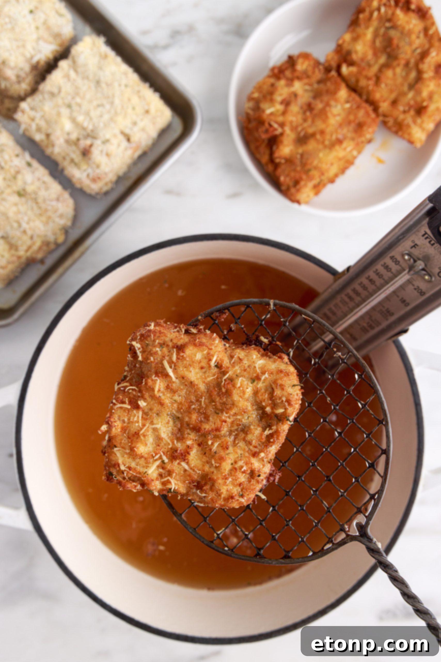 Hands dipping a lasagna slice into breading mixture