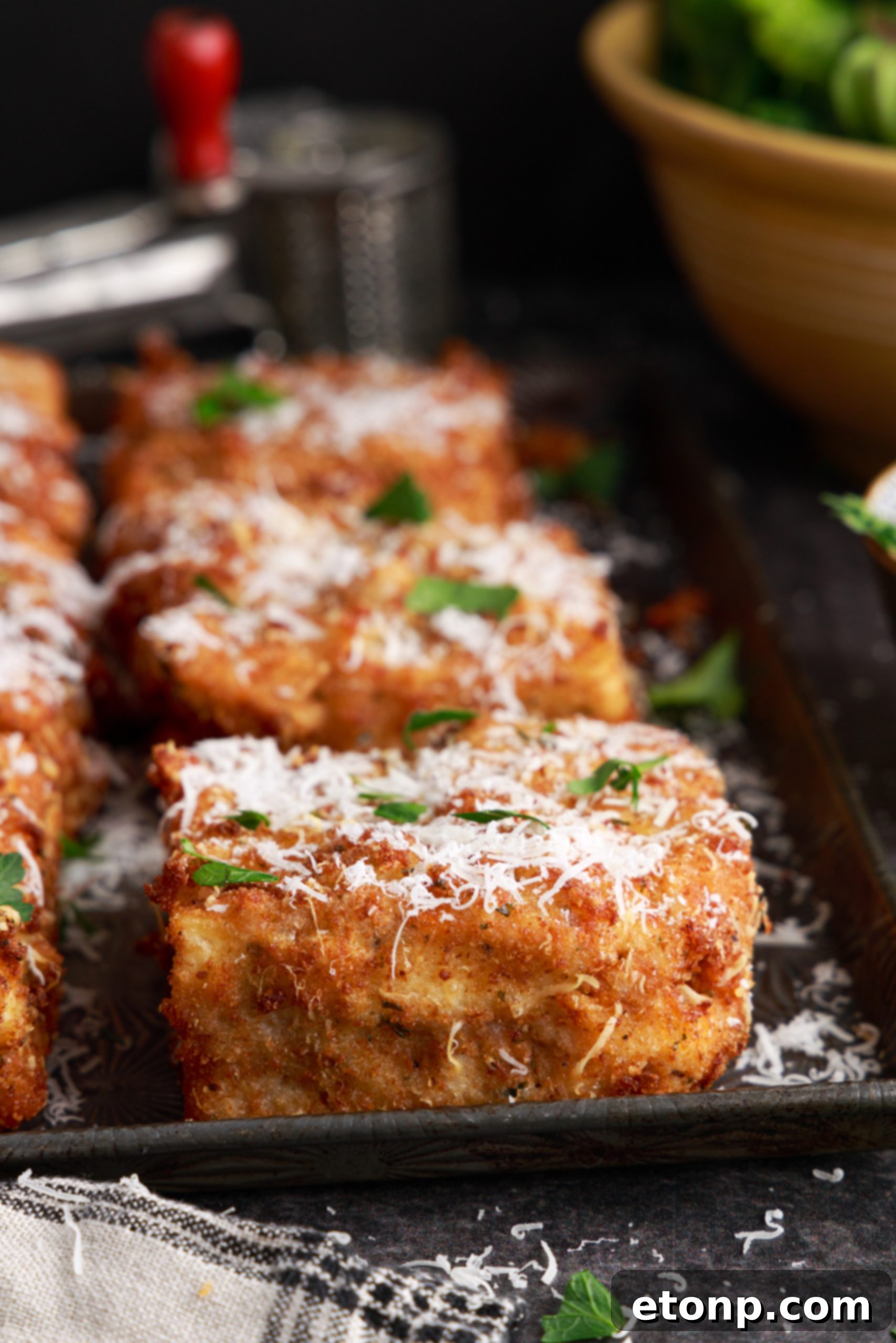 A plate of deep fried lasagna with a fork, ready to be eaten