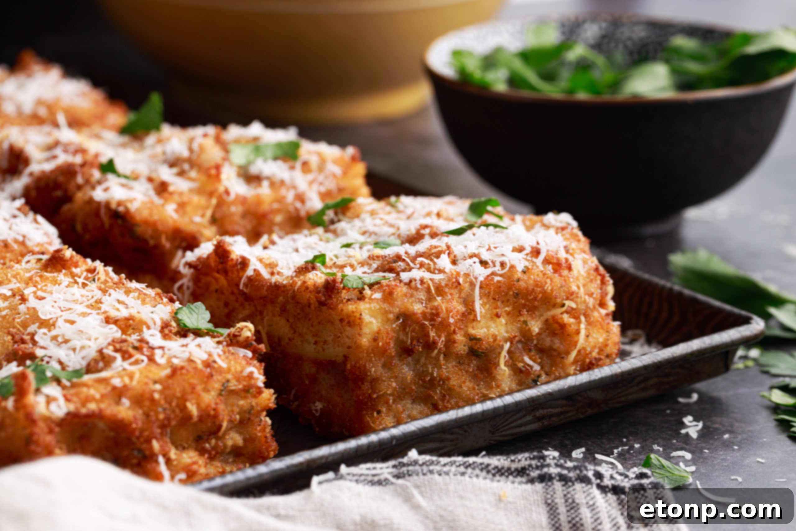 Close-up of deep fried lasagna with melted parmesan cheese on top