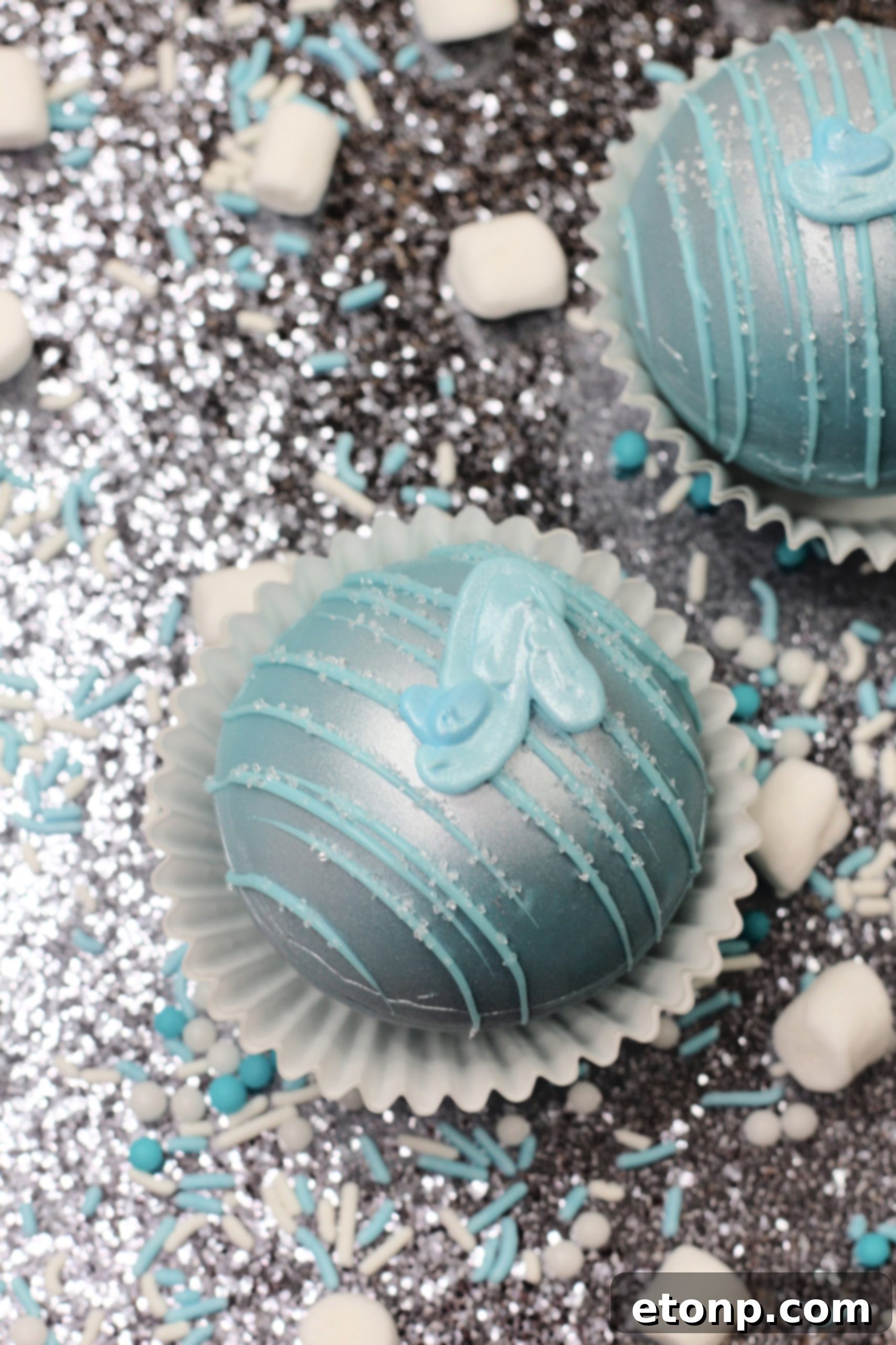 A hand gently placing a Cinderella Hot Cocoa Bomb into a mug, ready for hot milk to be poured over it, showing the start of the magical melting process.