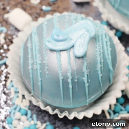 A close-up image of a decorated Cinderella Hot Cocoa Bomb, ready to be melted for a magical hot chocolate drink.