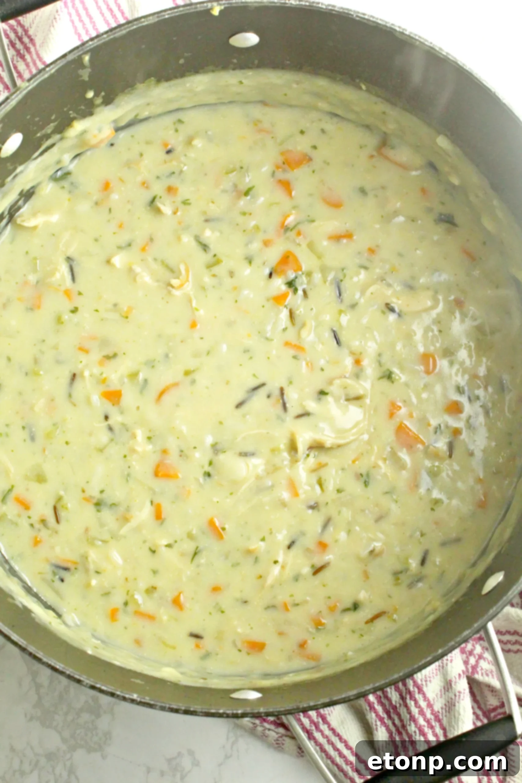 A selection of fresh, finely diced vegetables, including carrots, celery, and onions, ready for soup preparation.