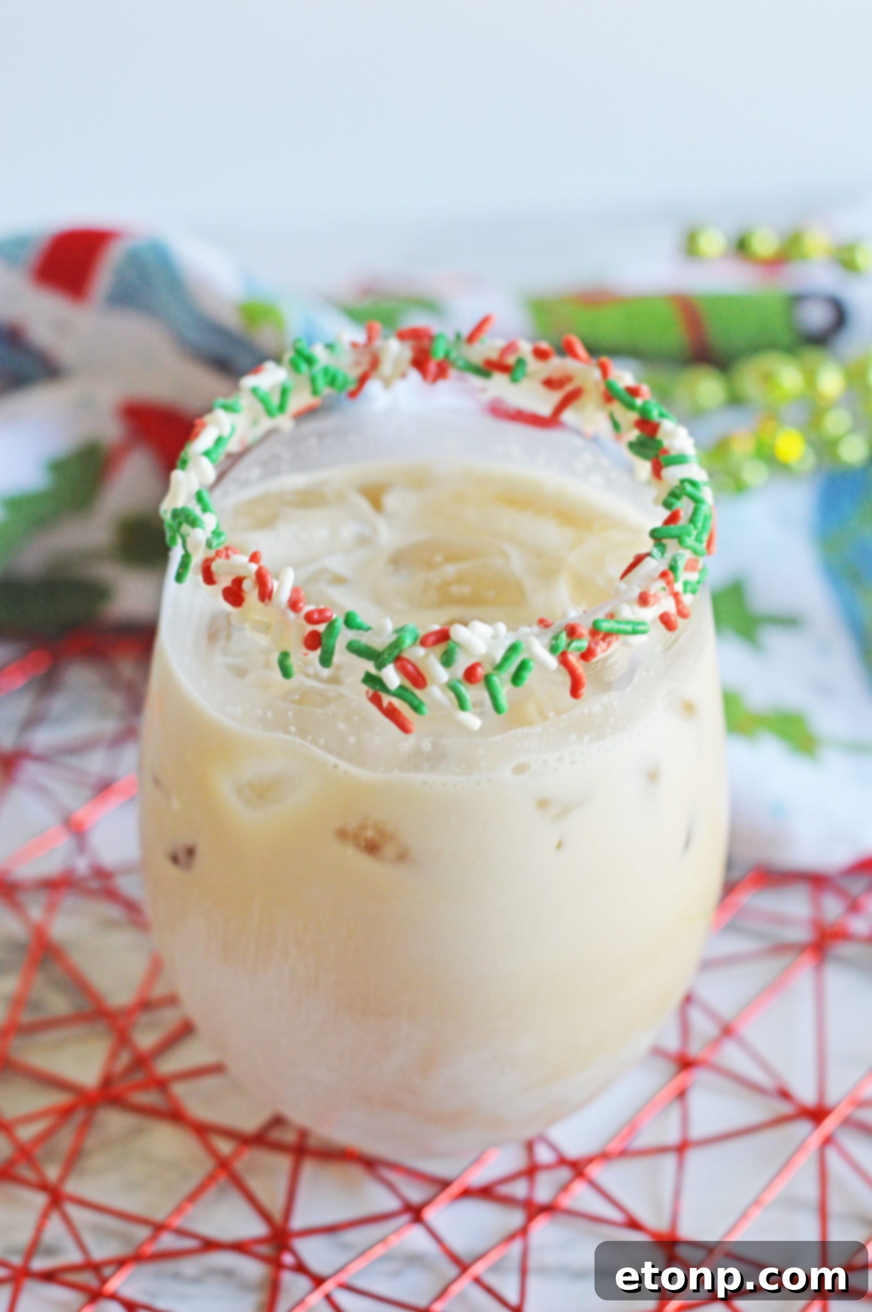 Delicious Christmas Cookie Cocktail with festive sprinkles on a white table.