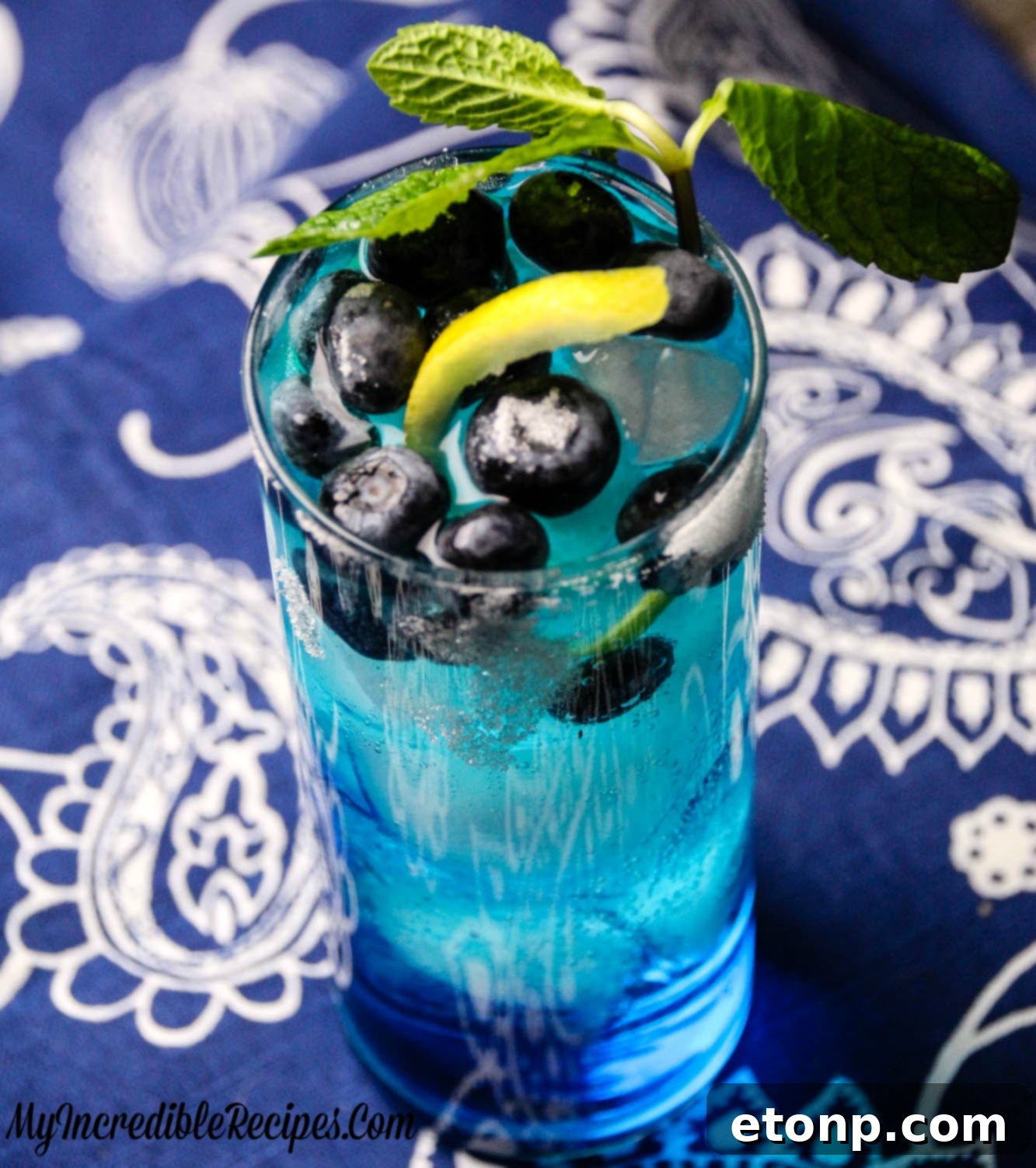 Zingy Blueberry Lemonade 7 Top-down view of the blue cocktail with lemon and mint garnish, showcasing its vibrant color