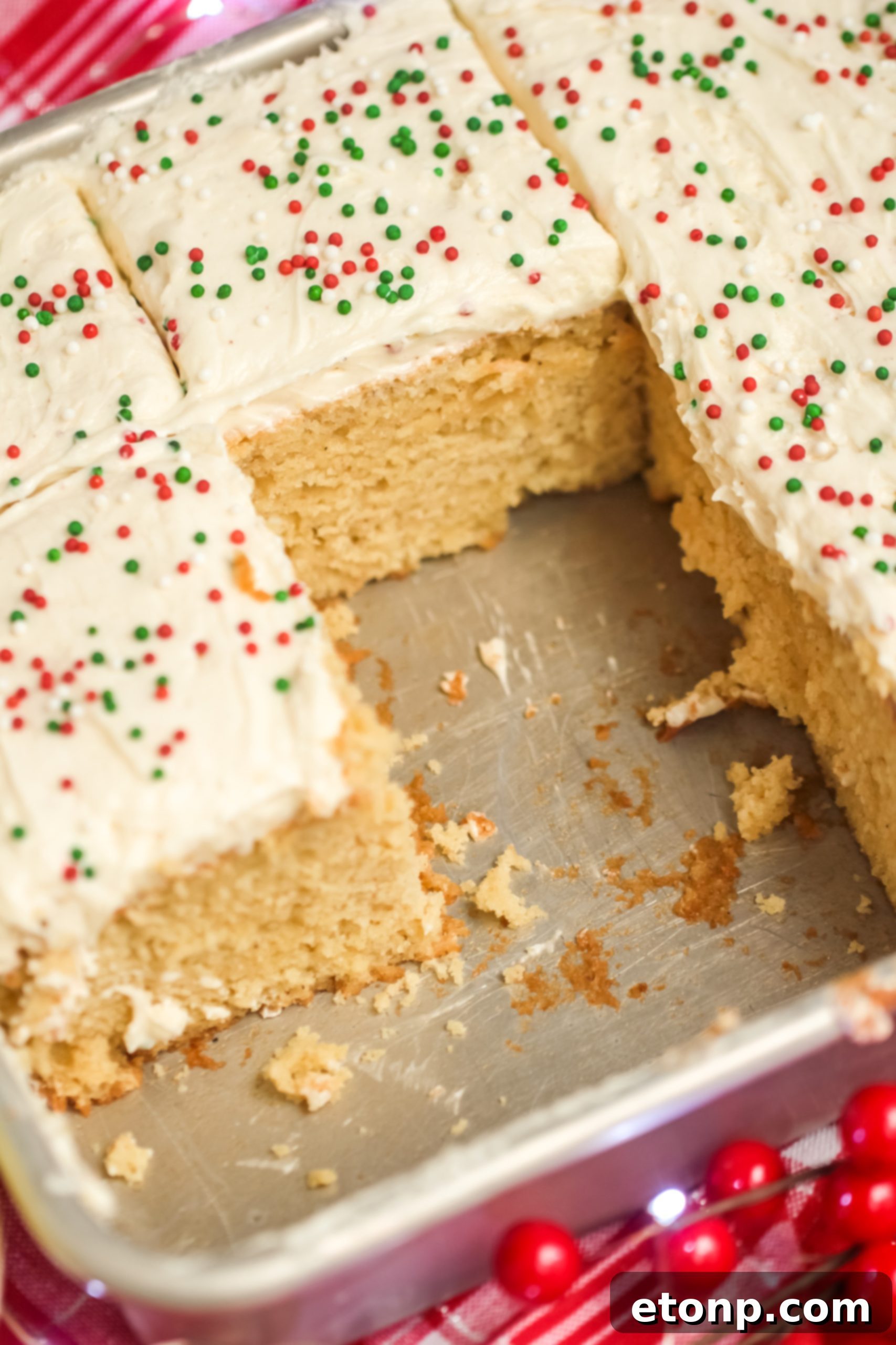 Holiday Eggnog Sheet Cake Delight 4 Close-up of a slice of Eggnog Sheet Cake with a fork, showcasing its moist texture and generous frosting.