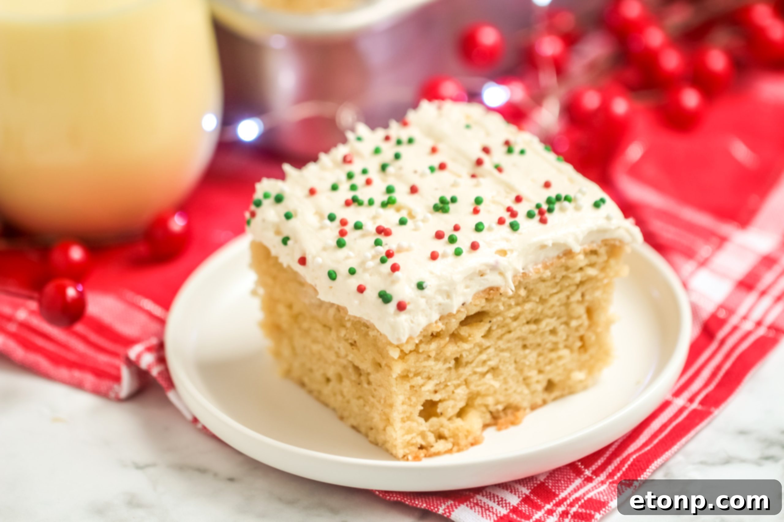 Holiday Eggnog Sheet Cake Delight 5 A whole Eggnog Sheet Cake, beautifully decorated with sprinkles, on a festive holiday table setting.