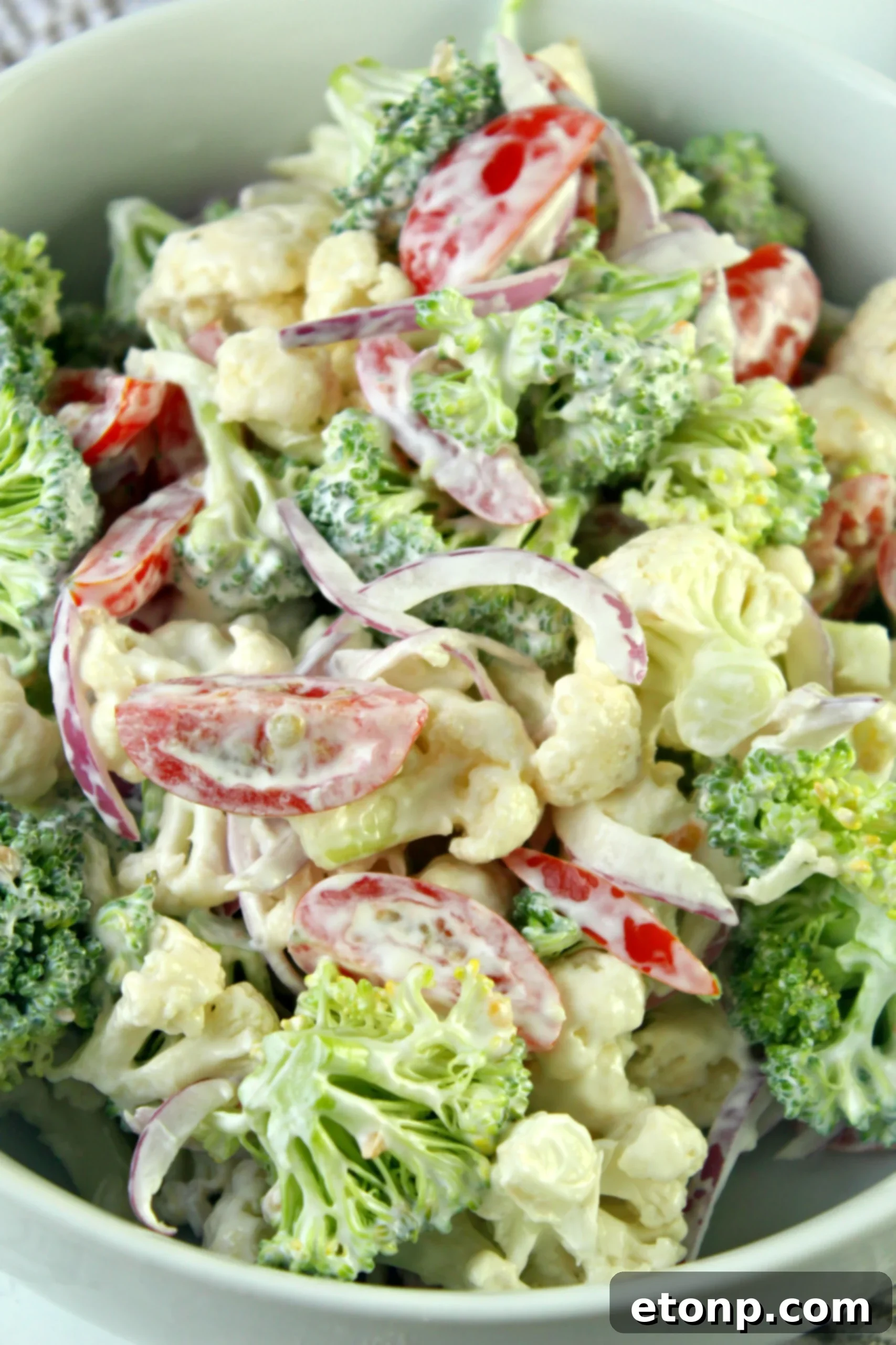 A beautifully arranged Christmas Salad, showcasing vibrant red tomatoes, green broccoli, and white cauliflower, perfect for a festive meal.