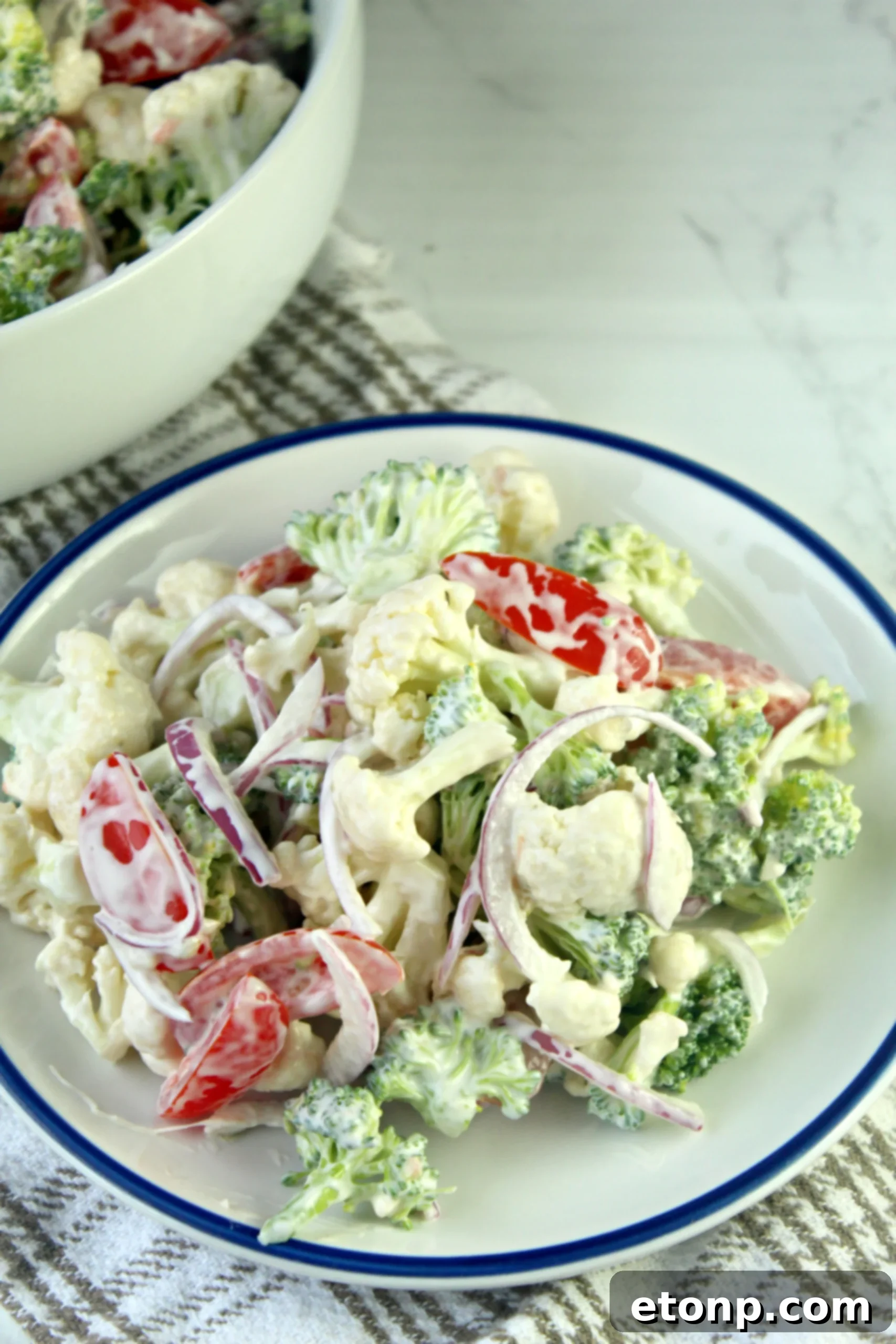 Close-up of the creamy dressing for Christmas Salad, showing mayonnaise, sour cream, and spices being whisked together.