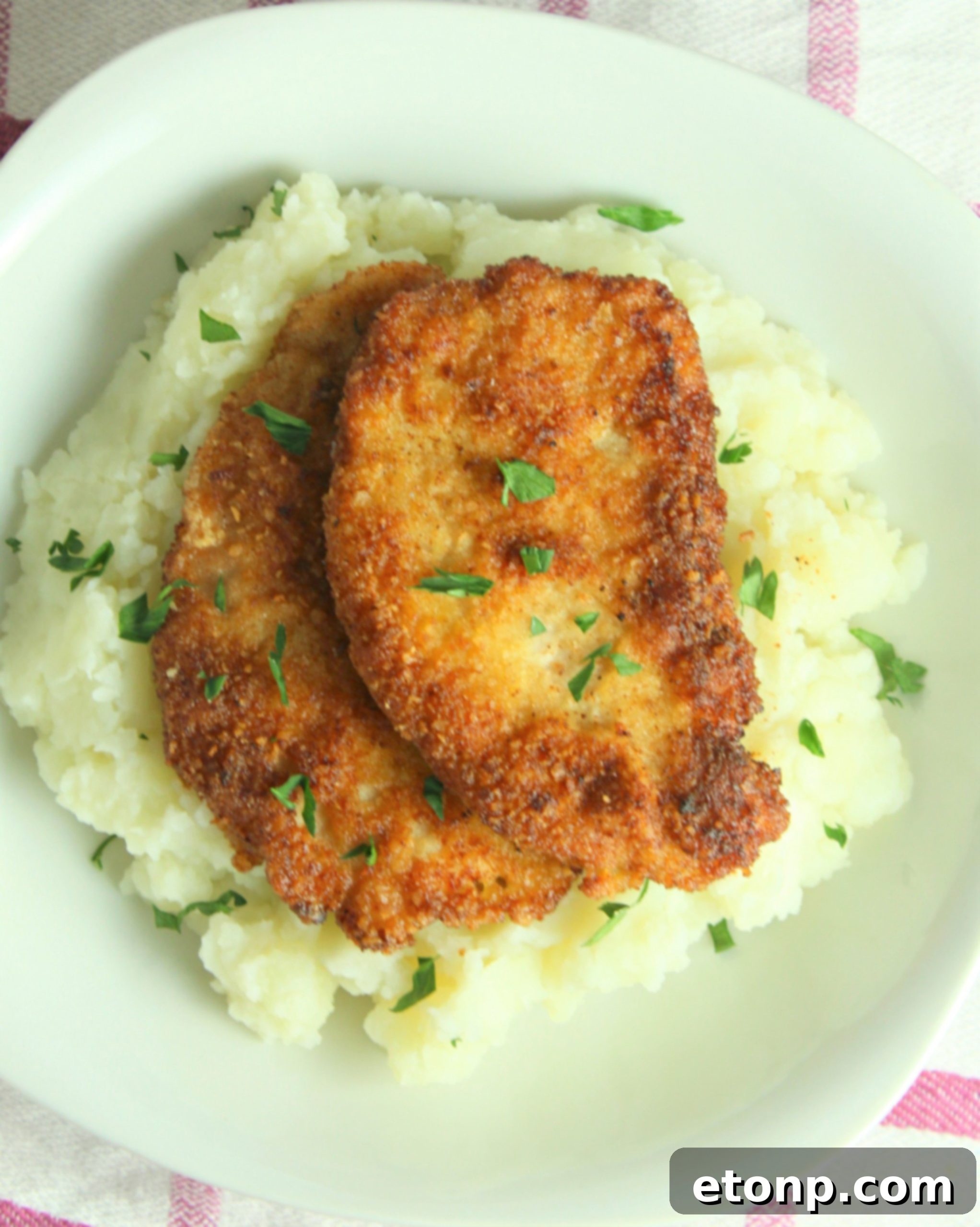 Freshly fried Pork Schnitzel resting on paper towels to drain excess oil