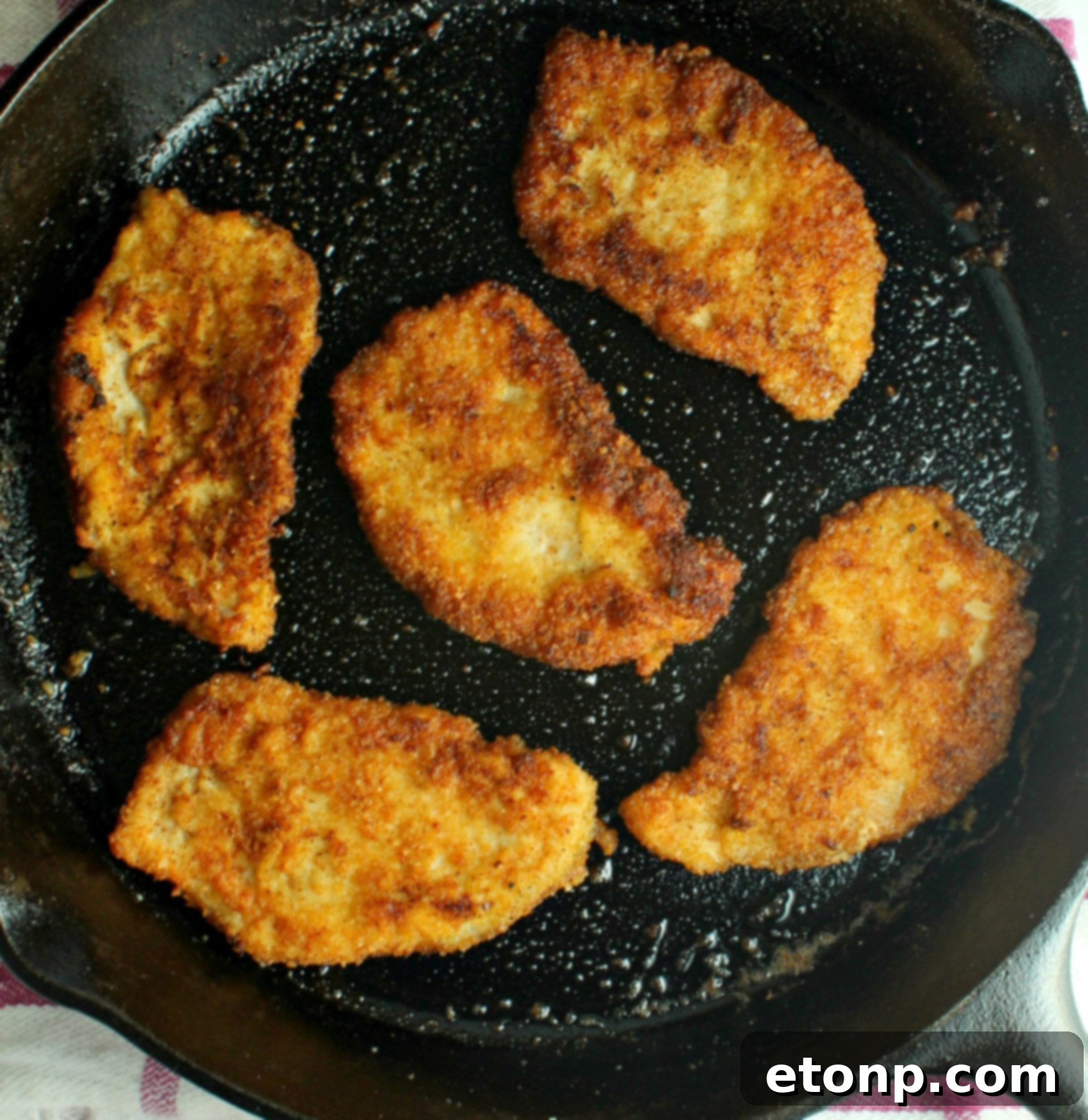 Breading process for Pork Schnitzel: floured chop dipped into egg wash