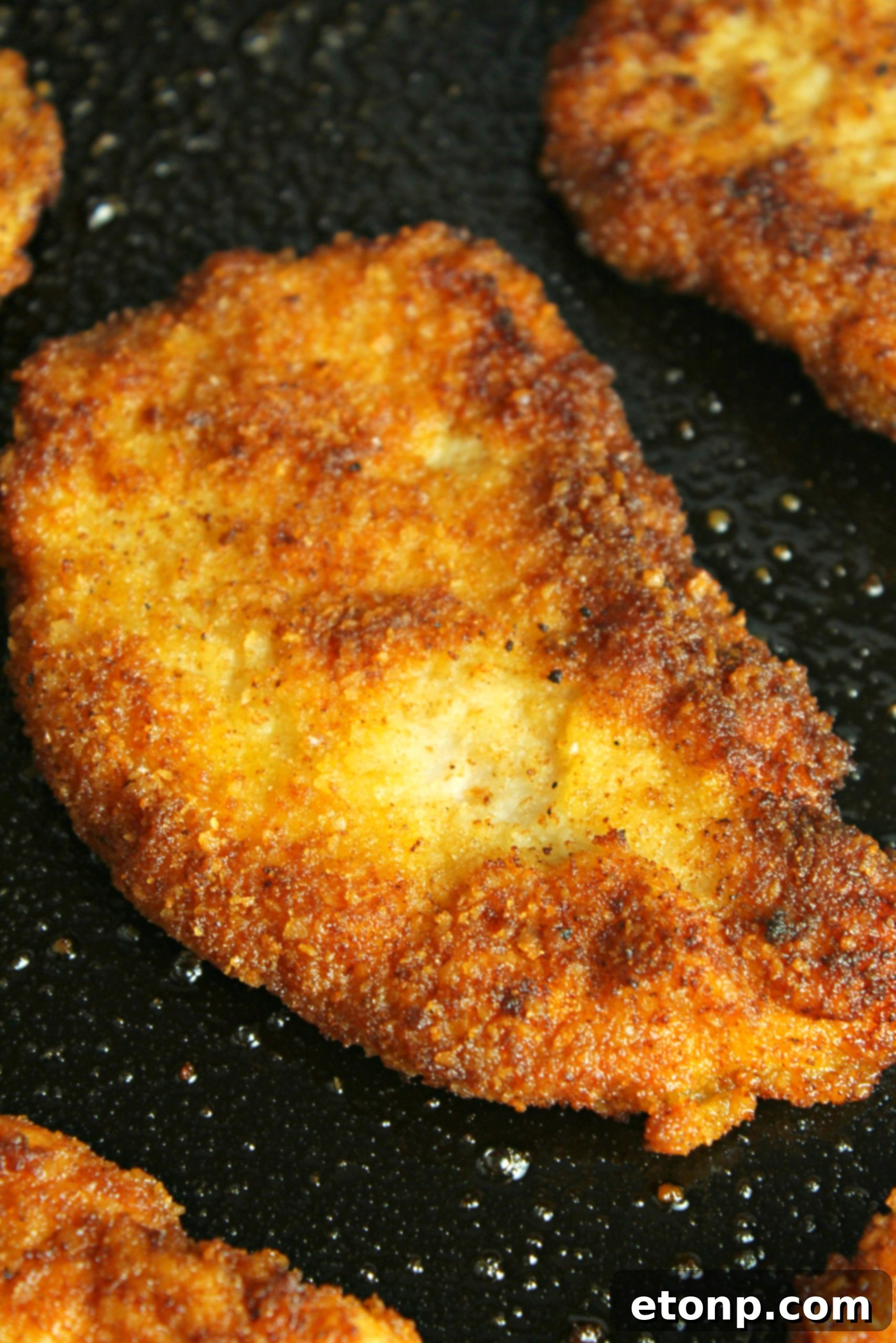 Two pieces of crispy Pork Schnitzel served with mashed potatoes and a lemon wedge