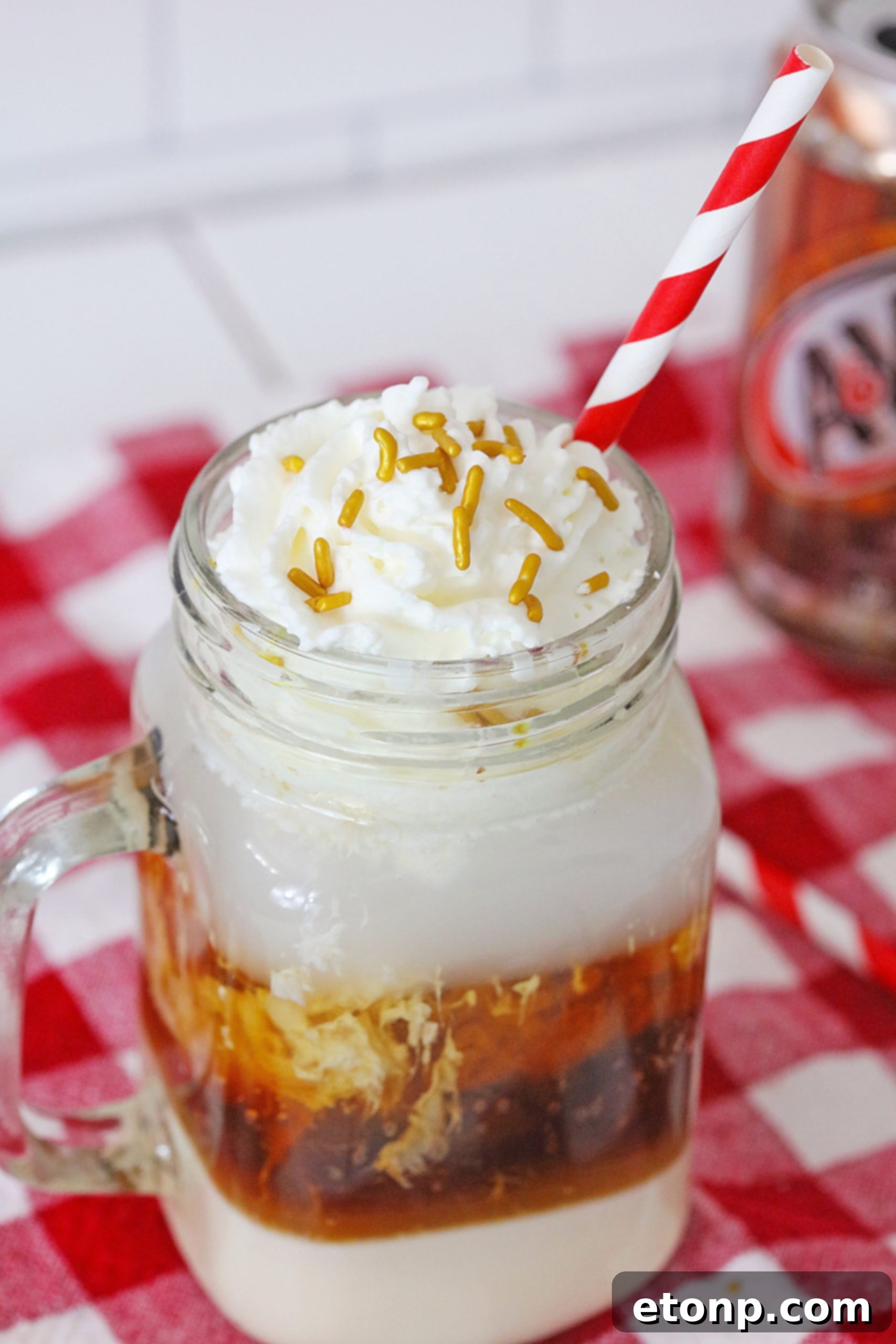 Decadent Layered Root Beer Float Cocktail 5 Layered Root Beer Float Cocktail ready to be enjoyed, garnished with whipped cream.