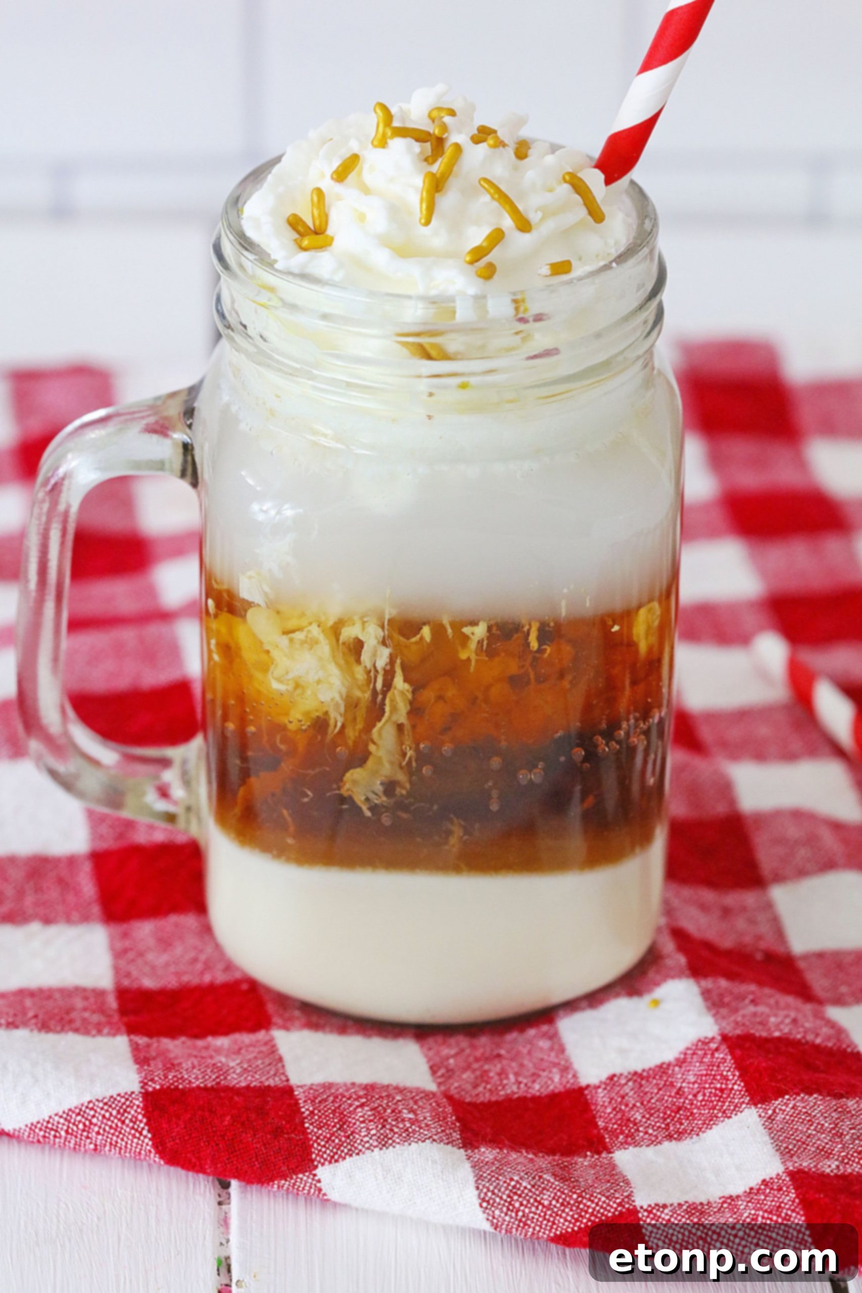 Decadent Layered Root Beer Float Cocktail 6 A frosty glass of Layered Root Beer Float Cocktail with a straw.