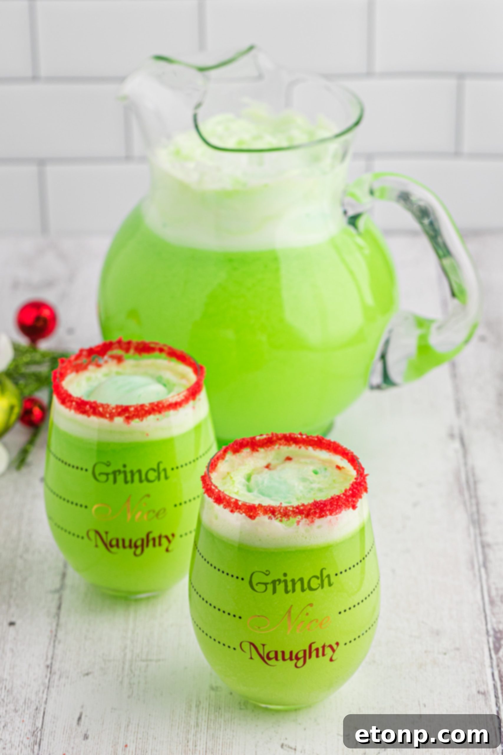The Grinch's Heart-Growing Holiday Brew 11 A festive holiday table setup featuring Grinch Punch in themed glasses, surrounded by Christmas decorations.