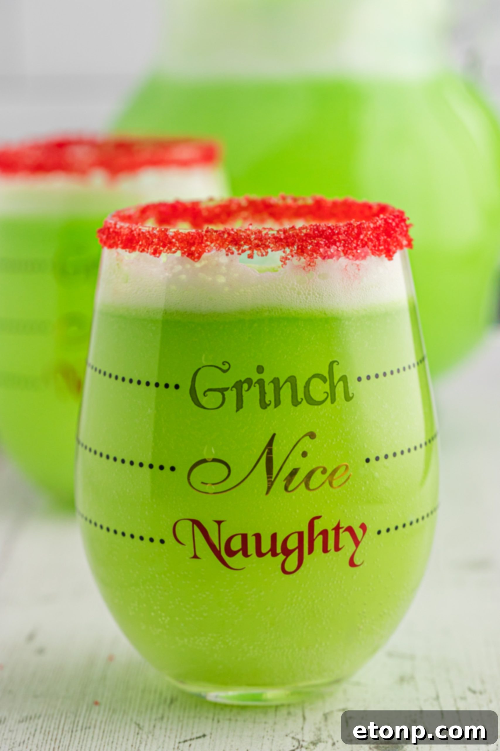 The Grinch's Heart-Growing Holiday Brew 8 A collection of glasses filled with Grinch Punch, set on a festive table, ready for a Christmas party.