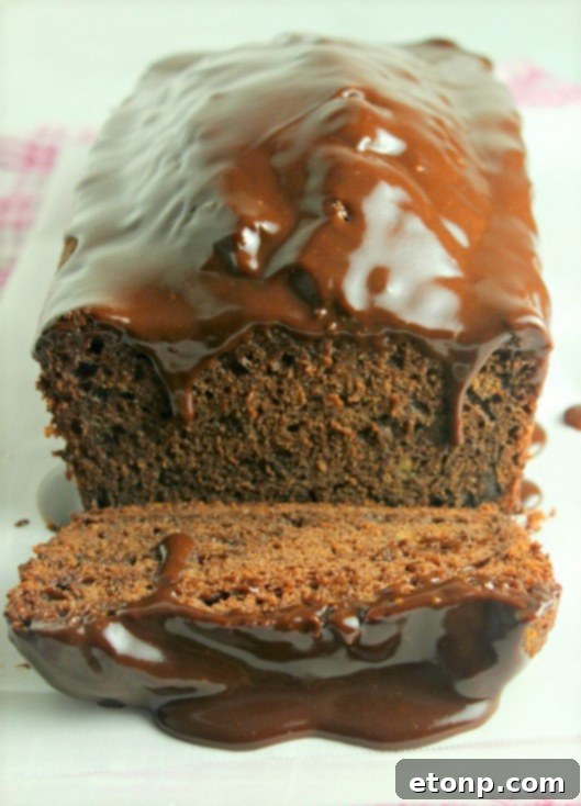 A close-up shot of the top of a loaf of double chocolate banana bread, showing its rich, dark texture.