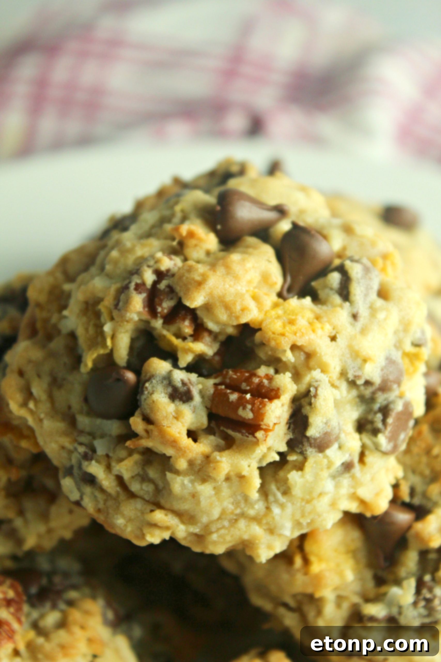 A baked Cowboy Cookie being picked up from a baking sheet.