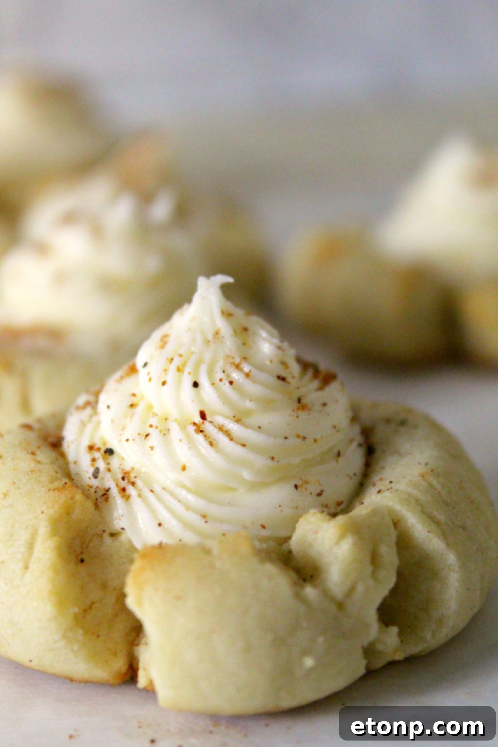A selection of beautiful Eggnog Thumbprint Cookies with rum frosting, arranged on a plate and ready for serving during a holiday gathering.