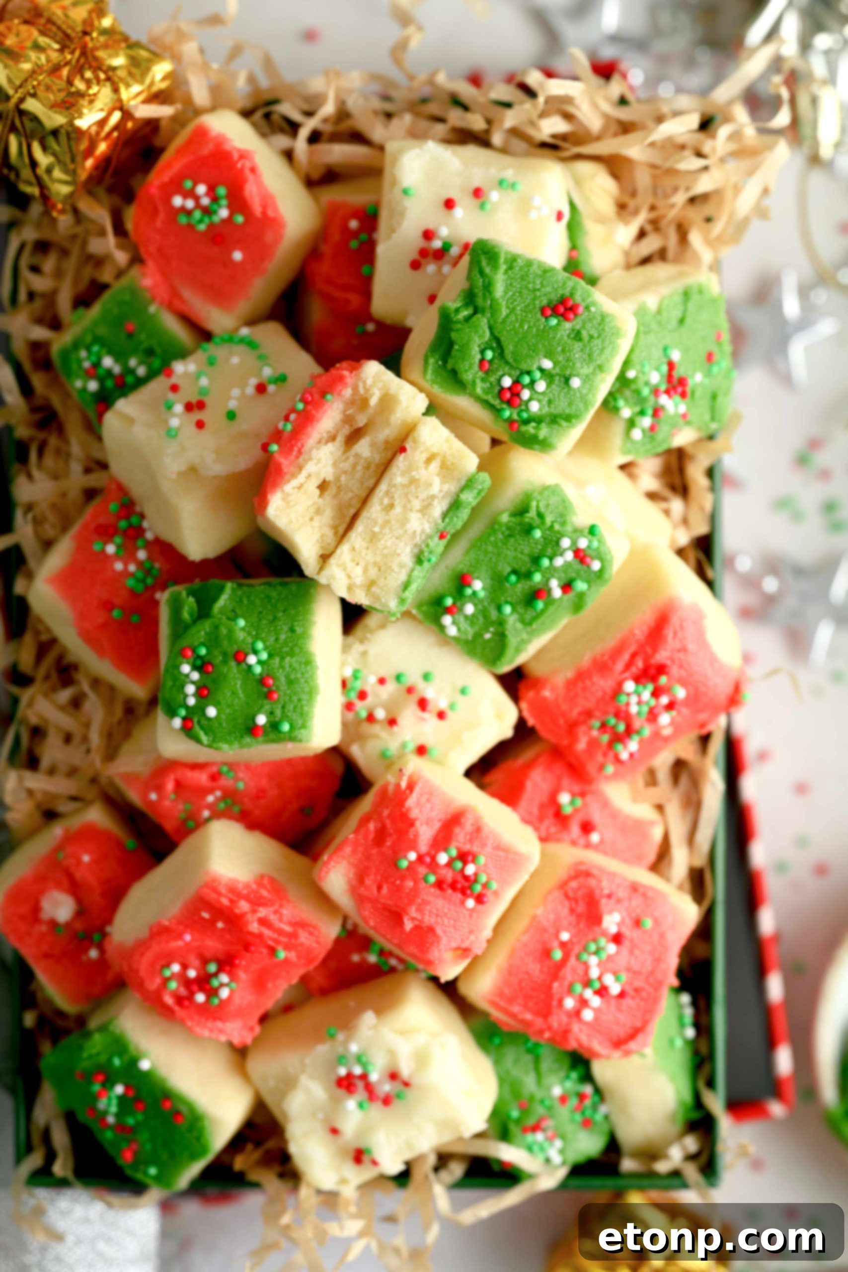 Close-up of freshly baked Christmas Sugar Cookie Bites, frosted with red, green, and white buttercream and topped with festive sprinkles.