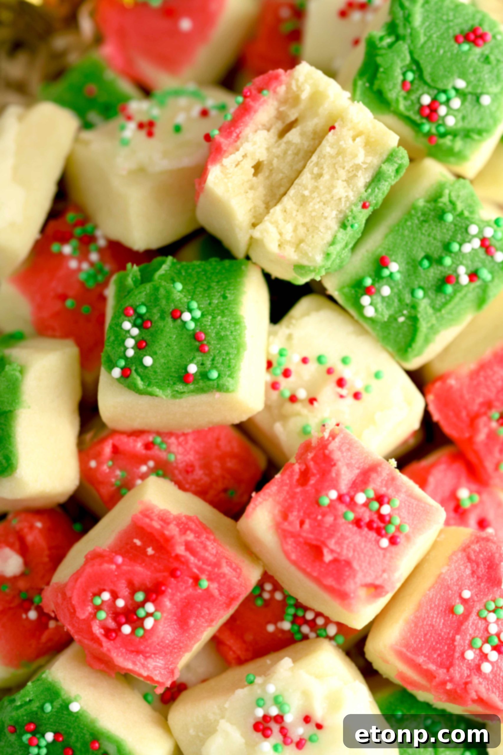 An overhead shot of colorful frosted Christmas Sugar Cookie Bites arranged artfully on a white platter.
