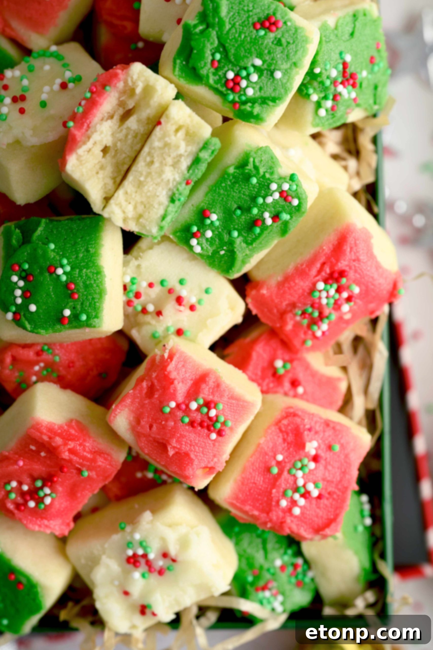 Close-up of a perfectly frosted red Christmas Sugar Cookie Bite with sprinkles.